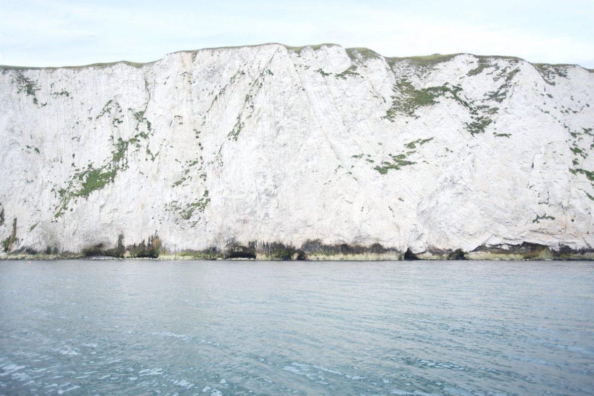 Close crop of white chalk cliffs and calm blue sea