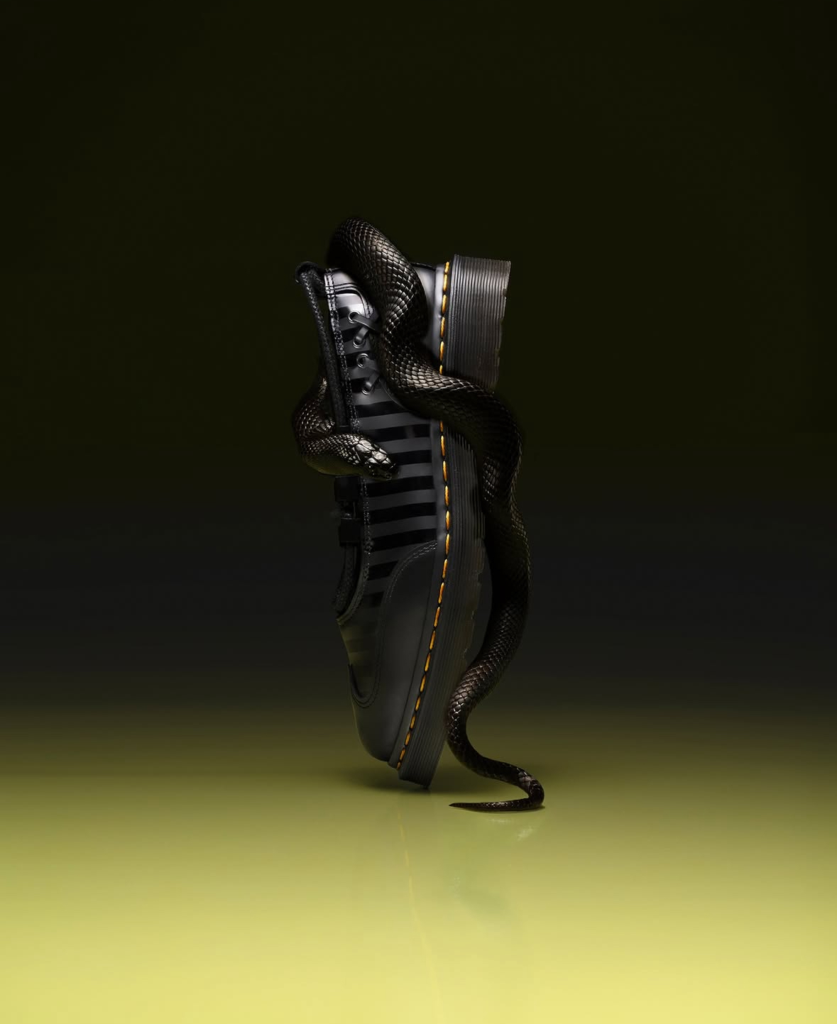 Humanoid figure in dark metallic armour with ribbed helmet details against black background, standing on yellow-green surface.