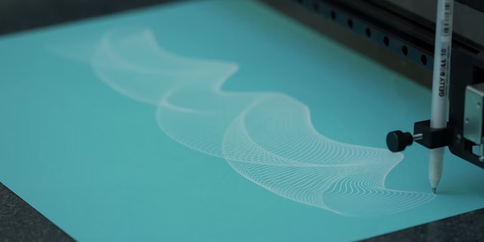 Close-up of a pen plotter drawing machine as it draws a pattern onto a page.