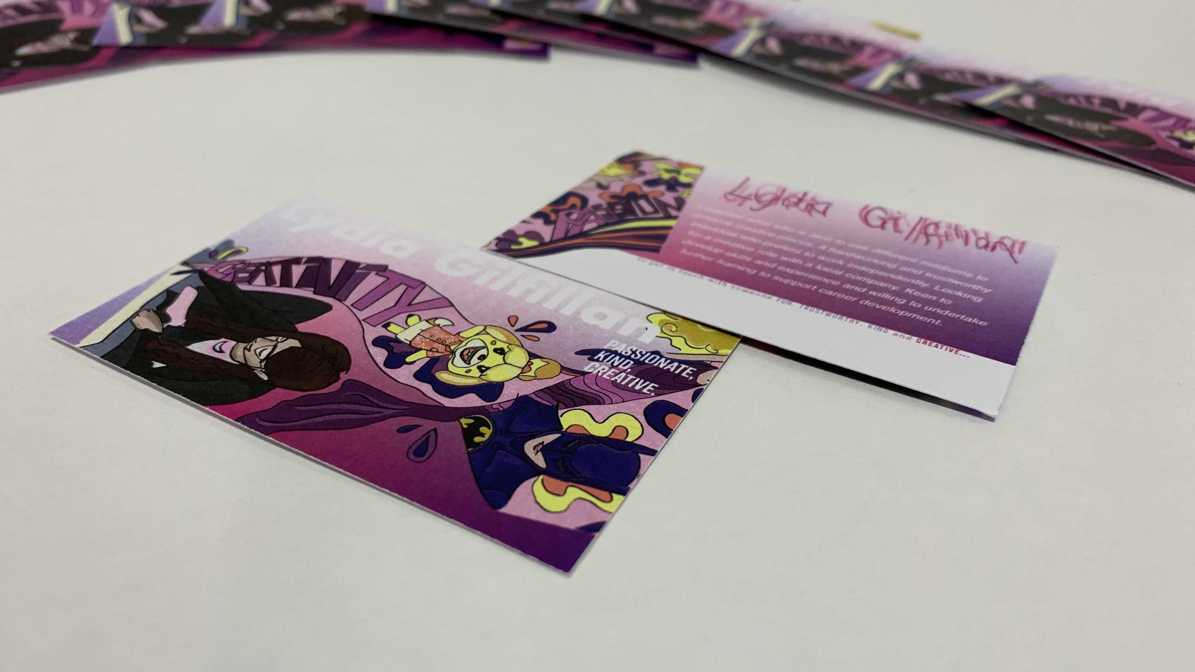 Two cards lying on a plain surface with colourful illustrations of characters such as Batman and Isabelle from the Animal Crossing series.