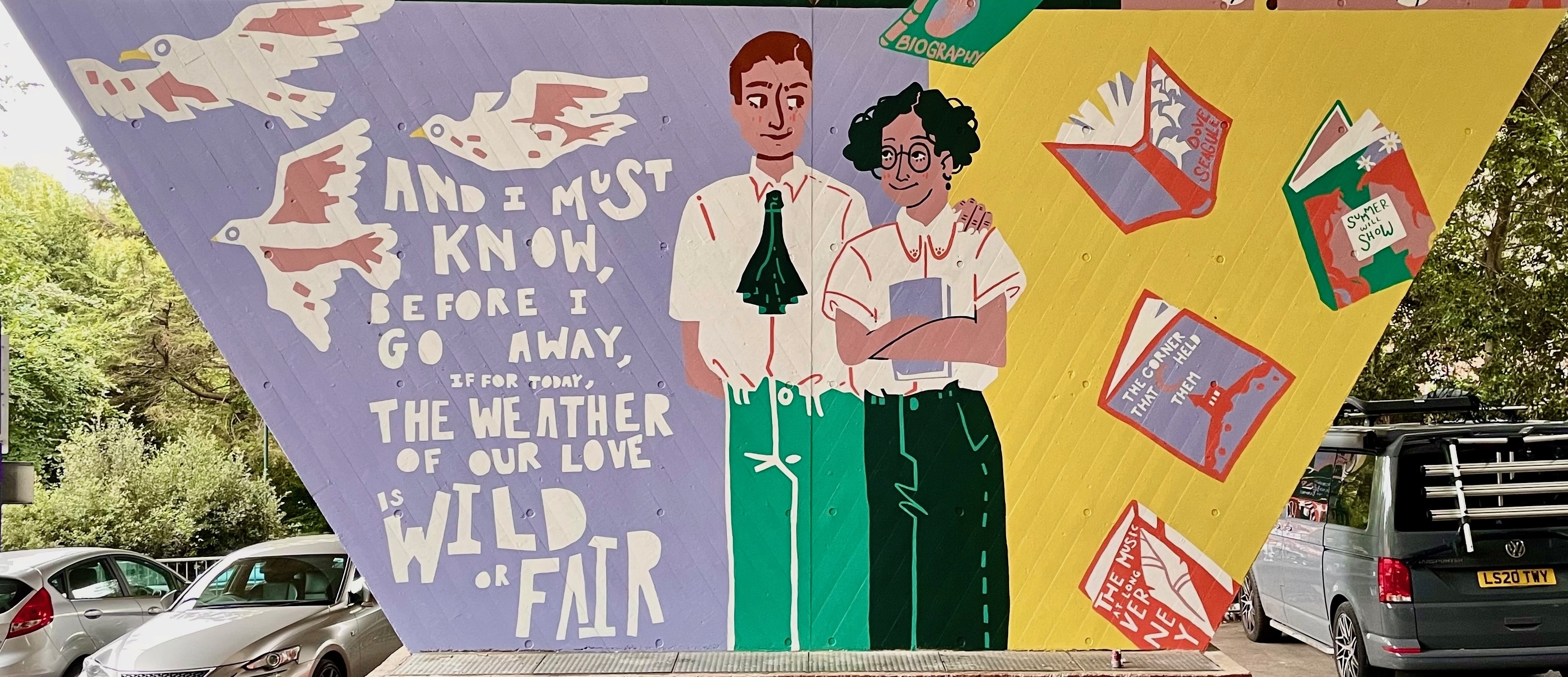 Part of a mural on a flyover pillar wall. Illustration of a man with his hand on a woman's shoulder; the woman is holding a book in her arms. Three birds are flying in the left corner with some words underneath, while several books are scattered on the right.