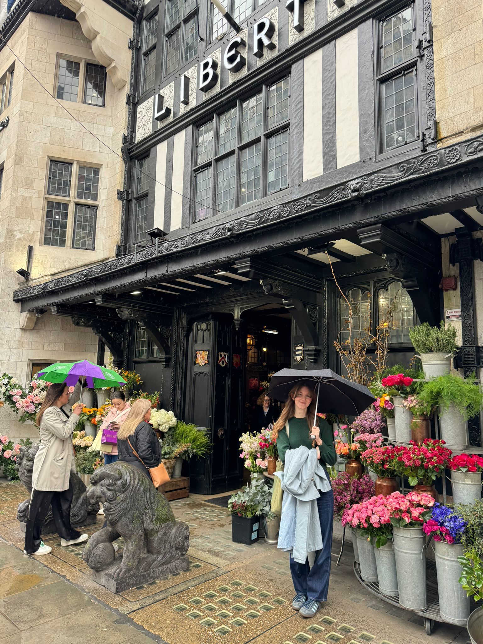 Ella Averty stood outside Liberty, holding an umbrella next to flowers.
