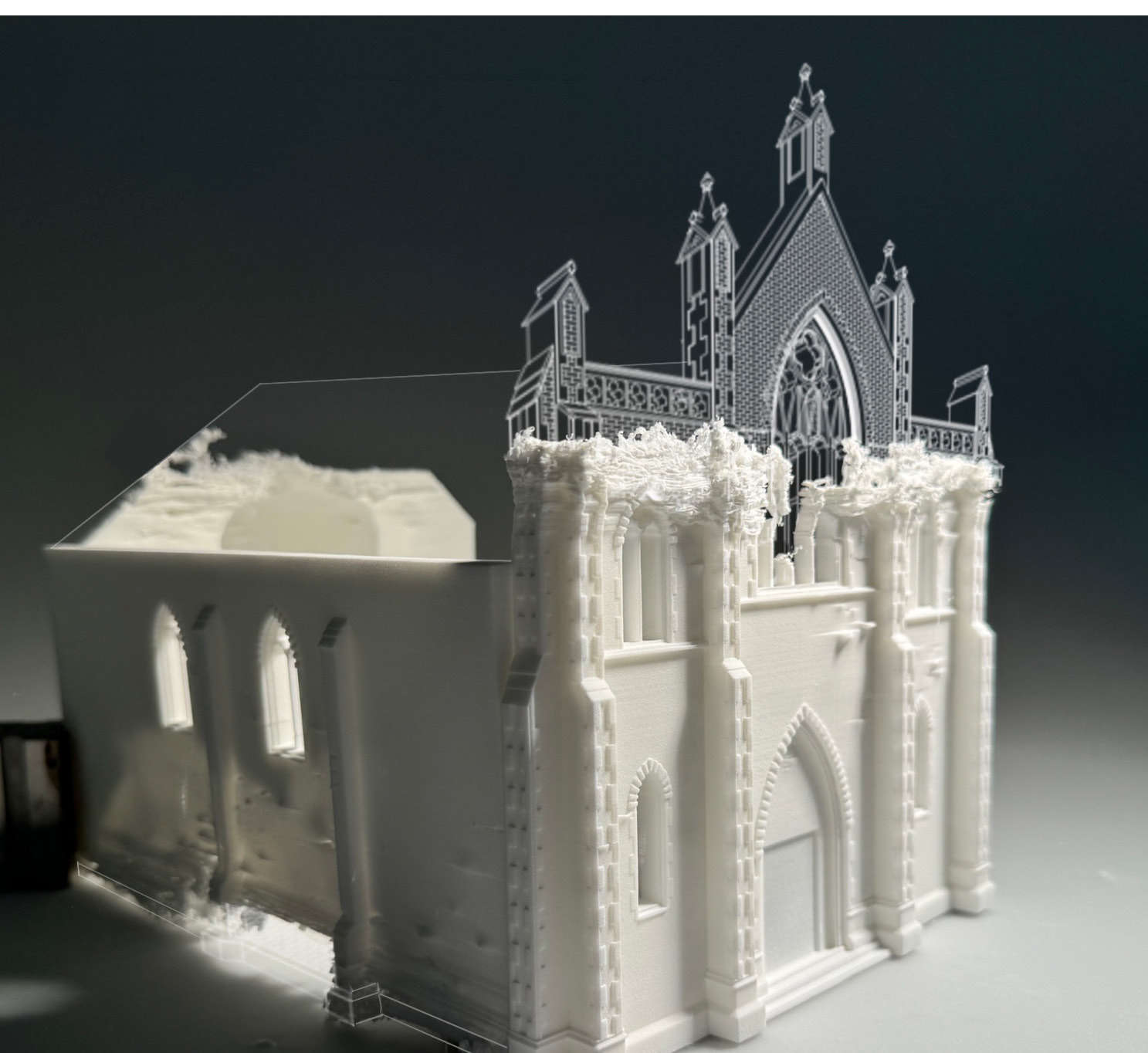 White 3D printed Gothic cathedral model with pointed arches, spires, and ornate details against dark grey background.