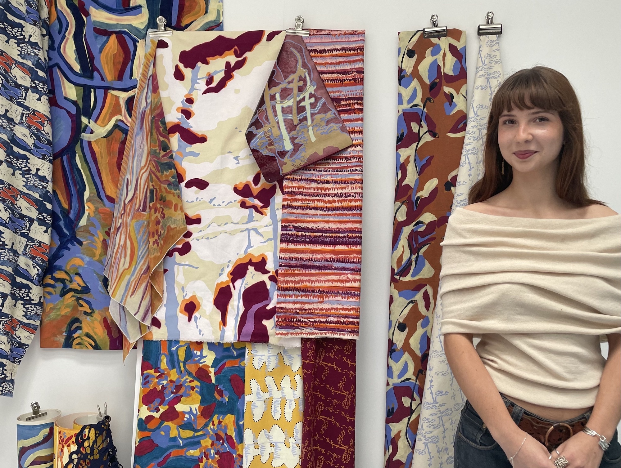 BA (Hons) Textiles student E Nathan standing next to samples from her Iberian Impressions collection.