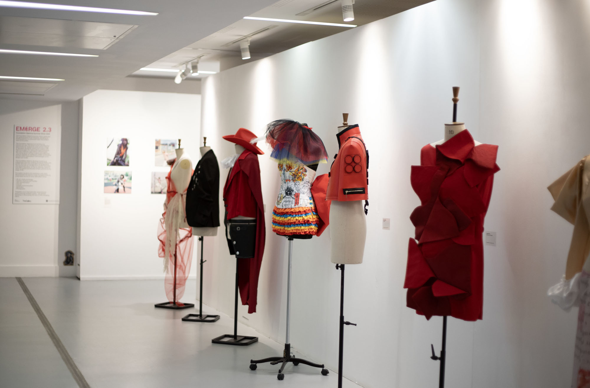 A row of mannequins dressed with different costumes lined up in front of a gallery wall during the 2023 Foundation Summer Shows.