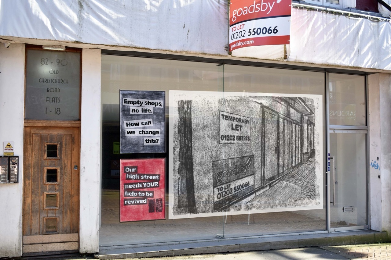 Empty storefront with an illustration of an abandoned shop and two posters, text about reviving our high streets.