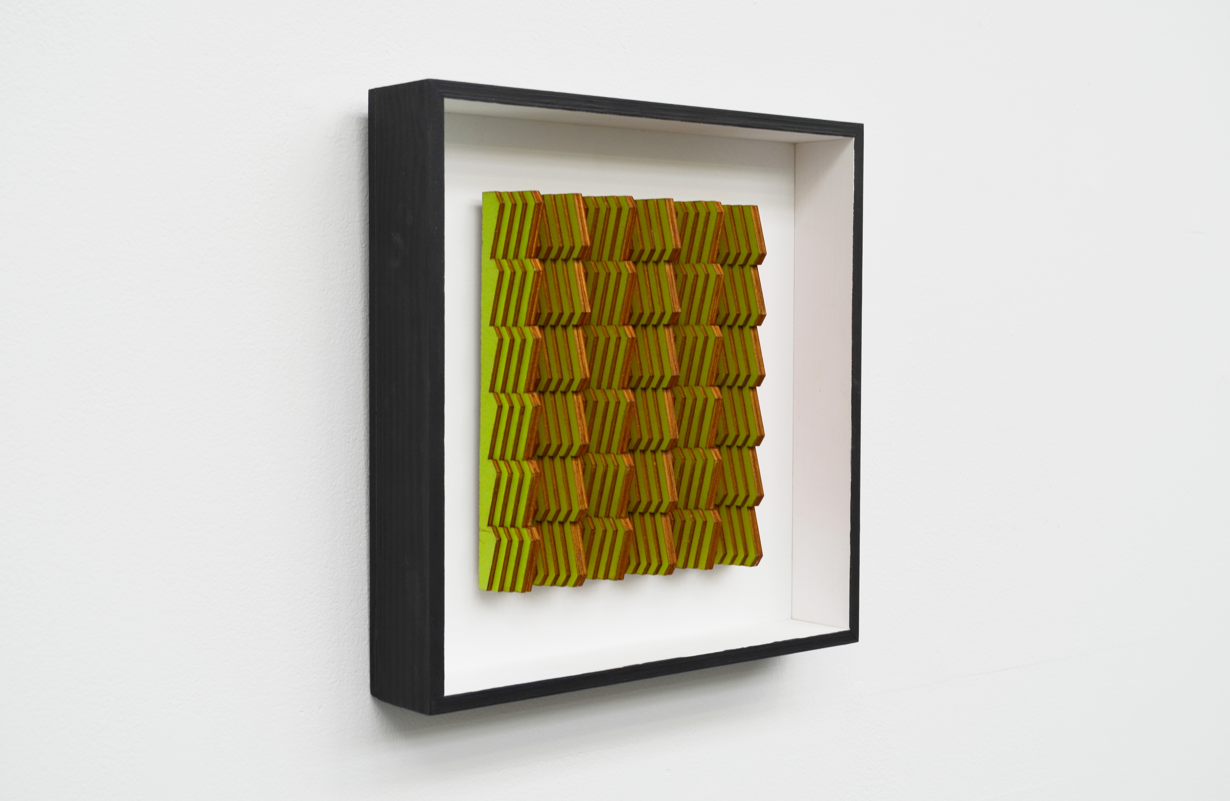 Framed artwork with green and yellow textured square featuring vertical wavy lines creating a rippled surface pattern.