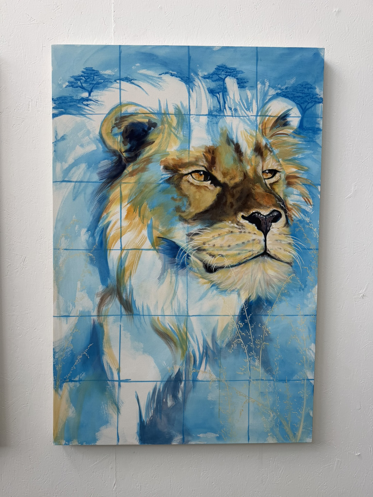 A large canvas artwork depicting a lion's head against a blue background, featuring vibrant colours and abstract brush strokes. The image is divided into a grid, giving it a tiled appearance.