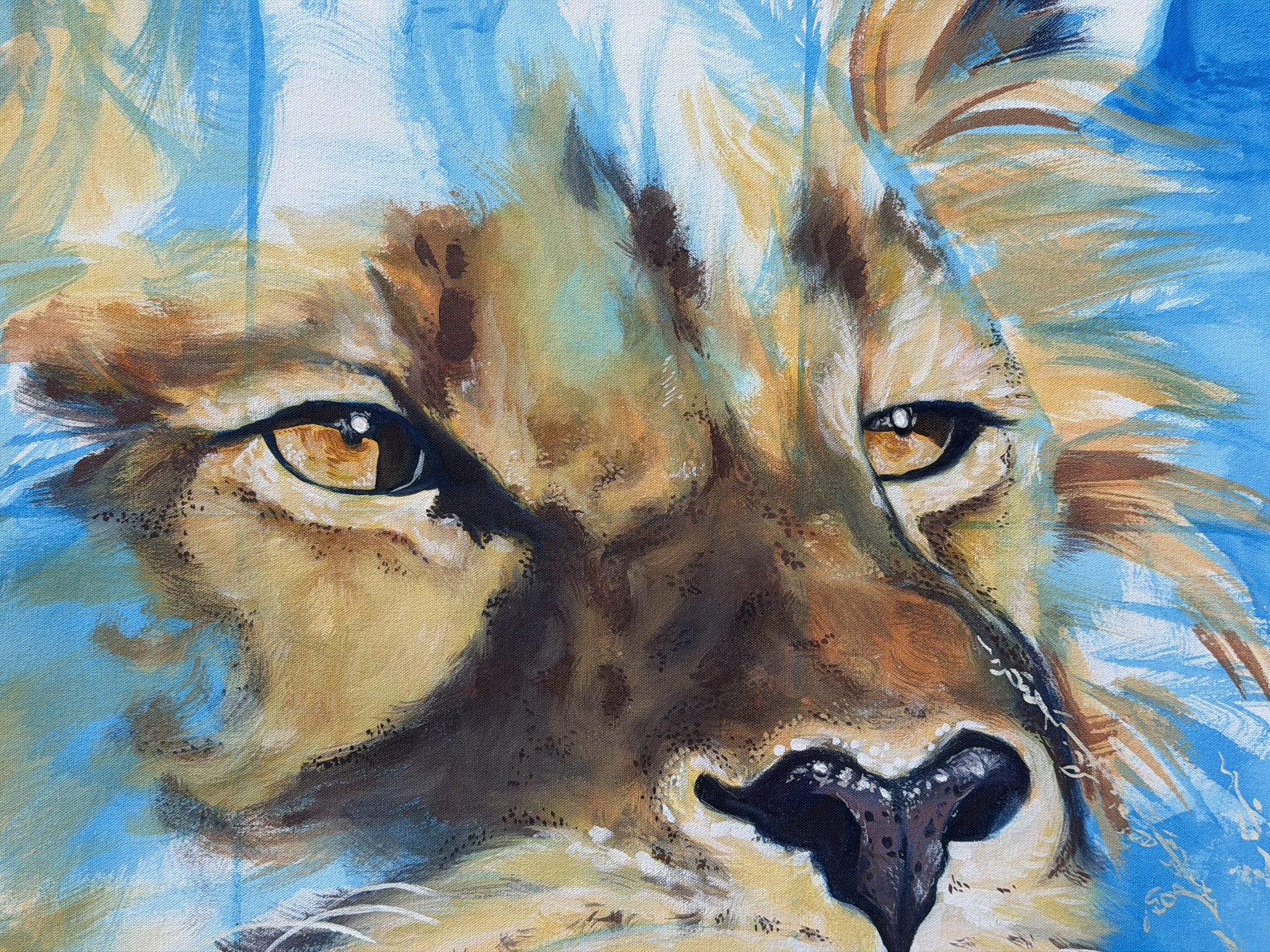 A close-up painting of a lion's face, featuring intense golden eyes and a detailed snout. The background consists of various shades of blue, enhancing the lion's features.