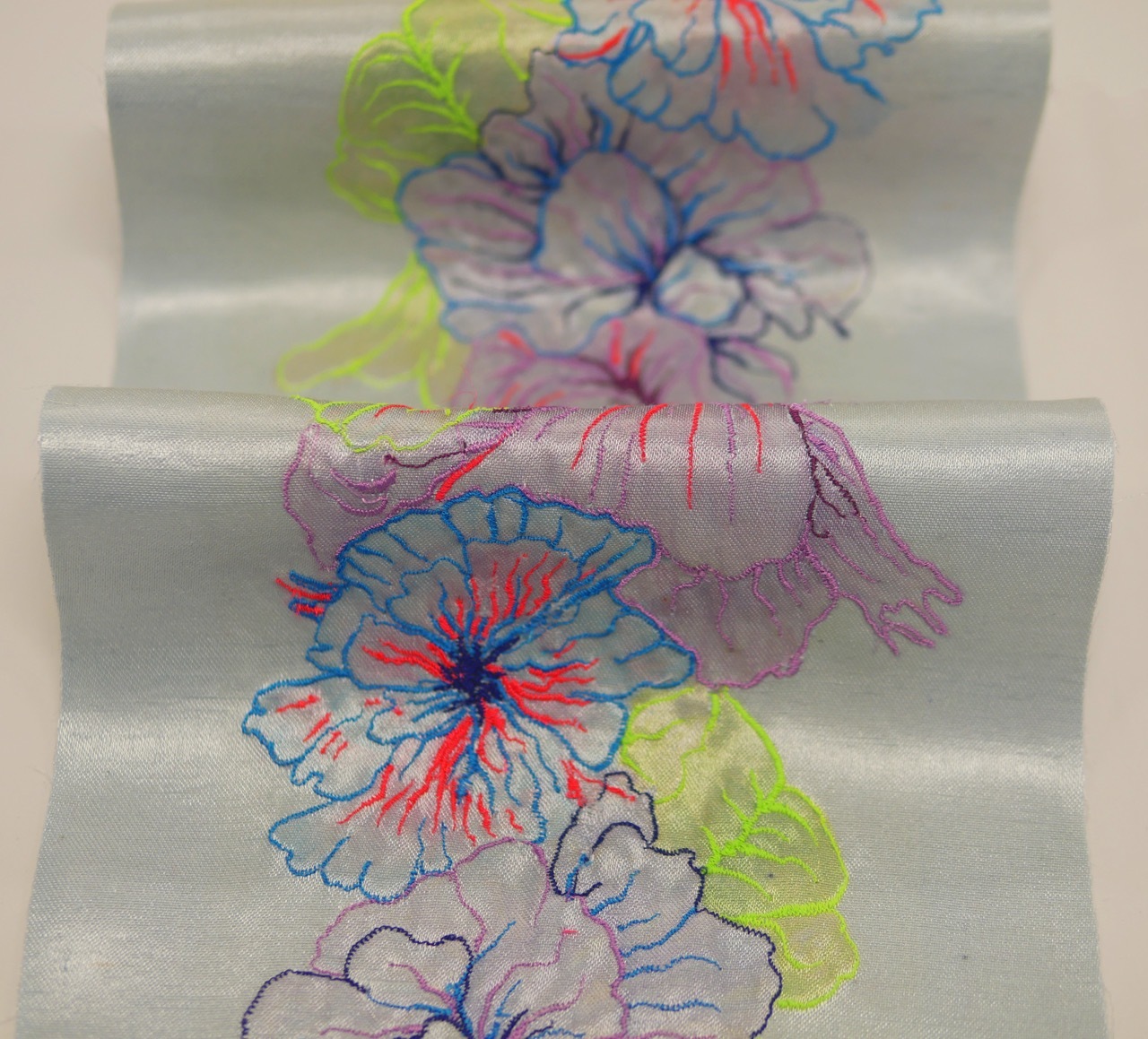 Coloured pencil drawing on white paper showing layered floral forms in blue, red, purple and green with loose, sketchy outlines.