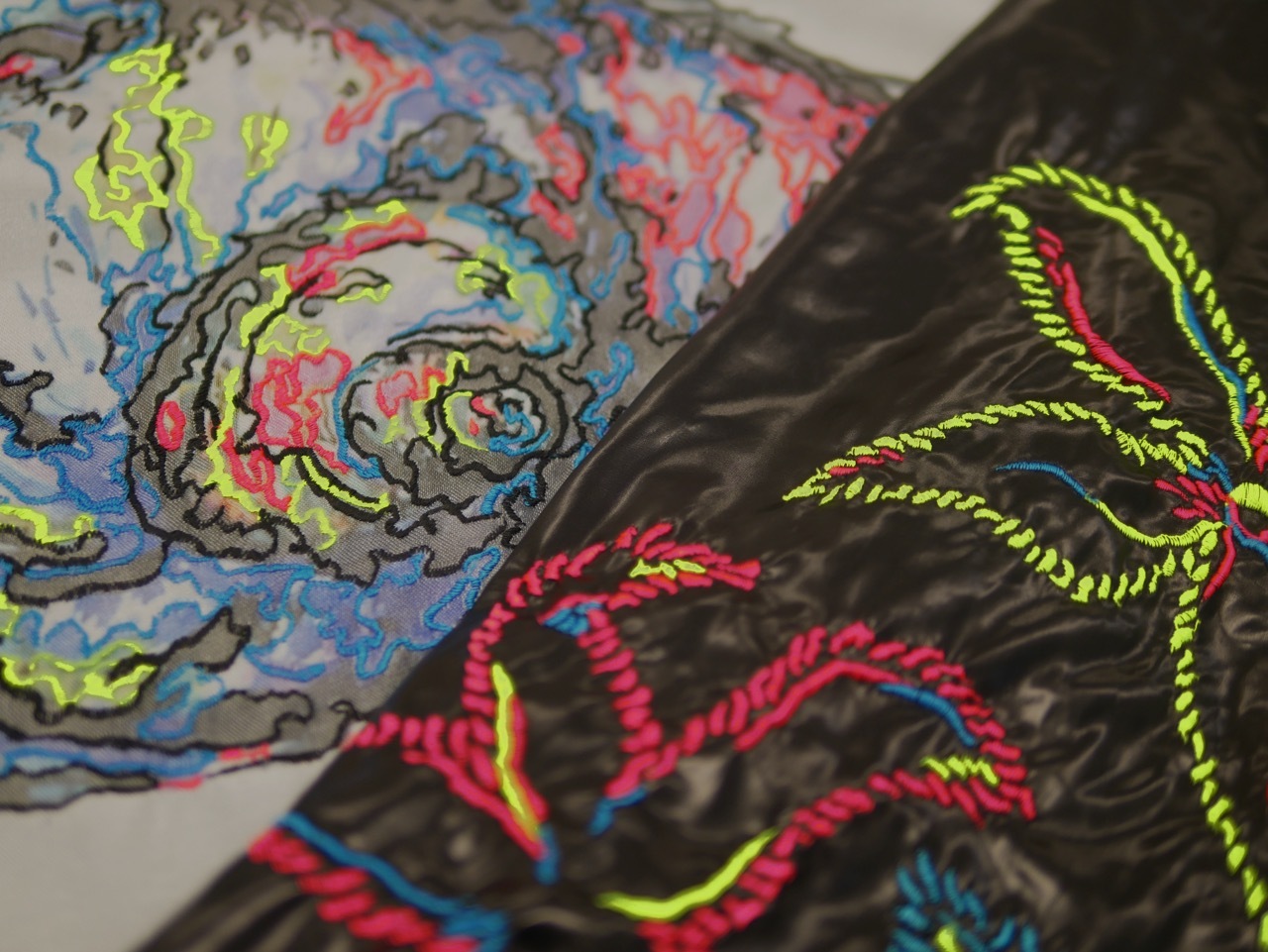 Colourful drawing with swirling patterns in blues, pinks, and greens on left, bright yellow and pink linear shapes on dark background on right.