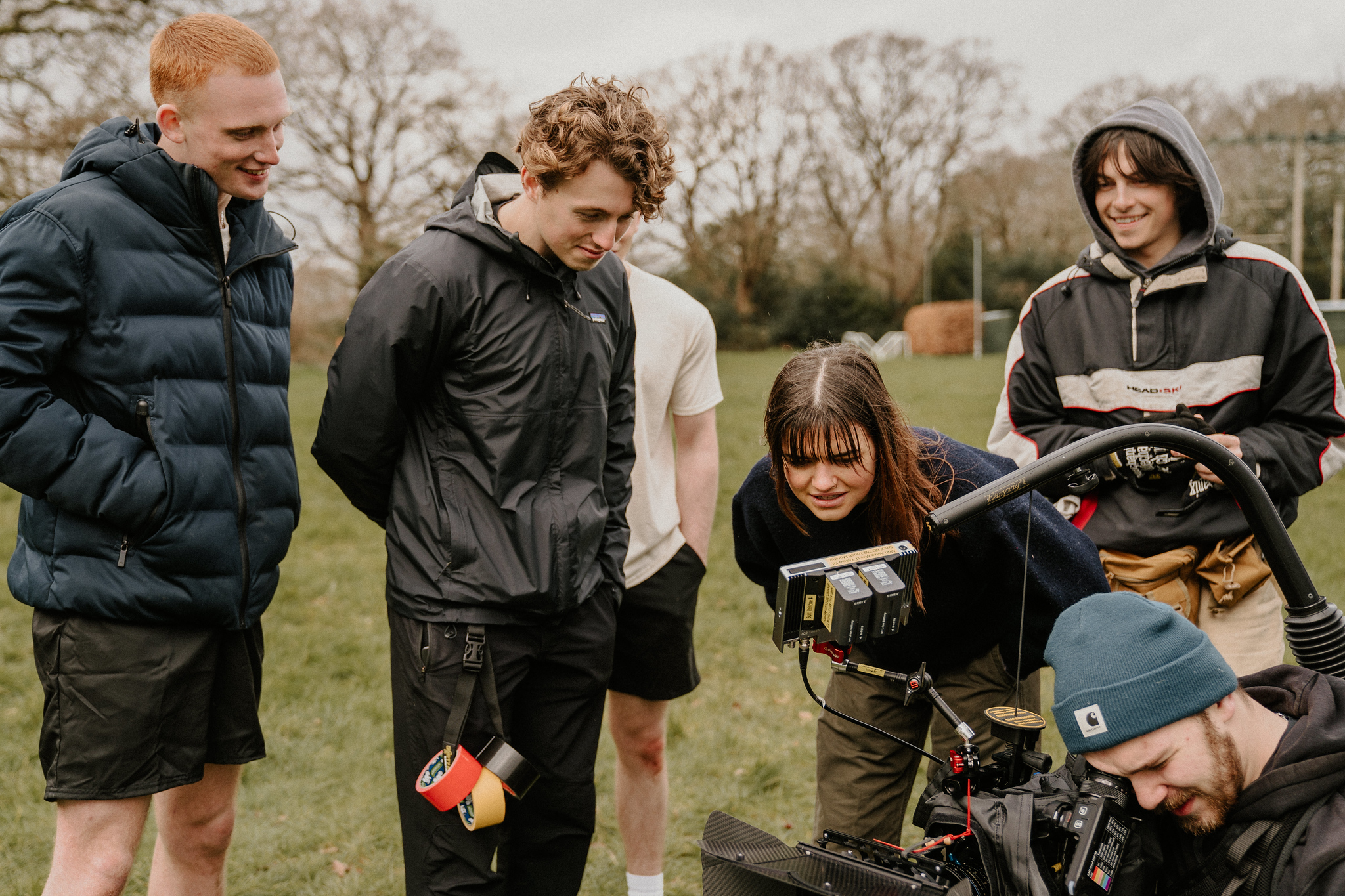 BTS shot from Eyes, Front showing the crew watching back footage on camera equipment.