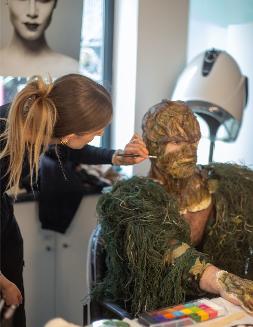 Make-up application for 'swamp thing' character.