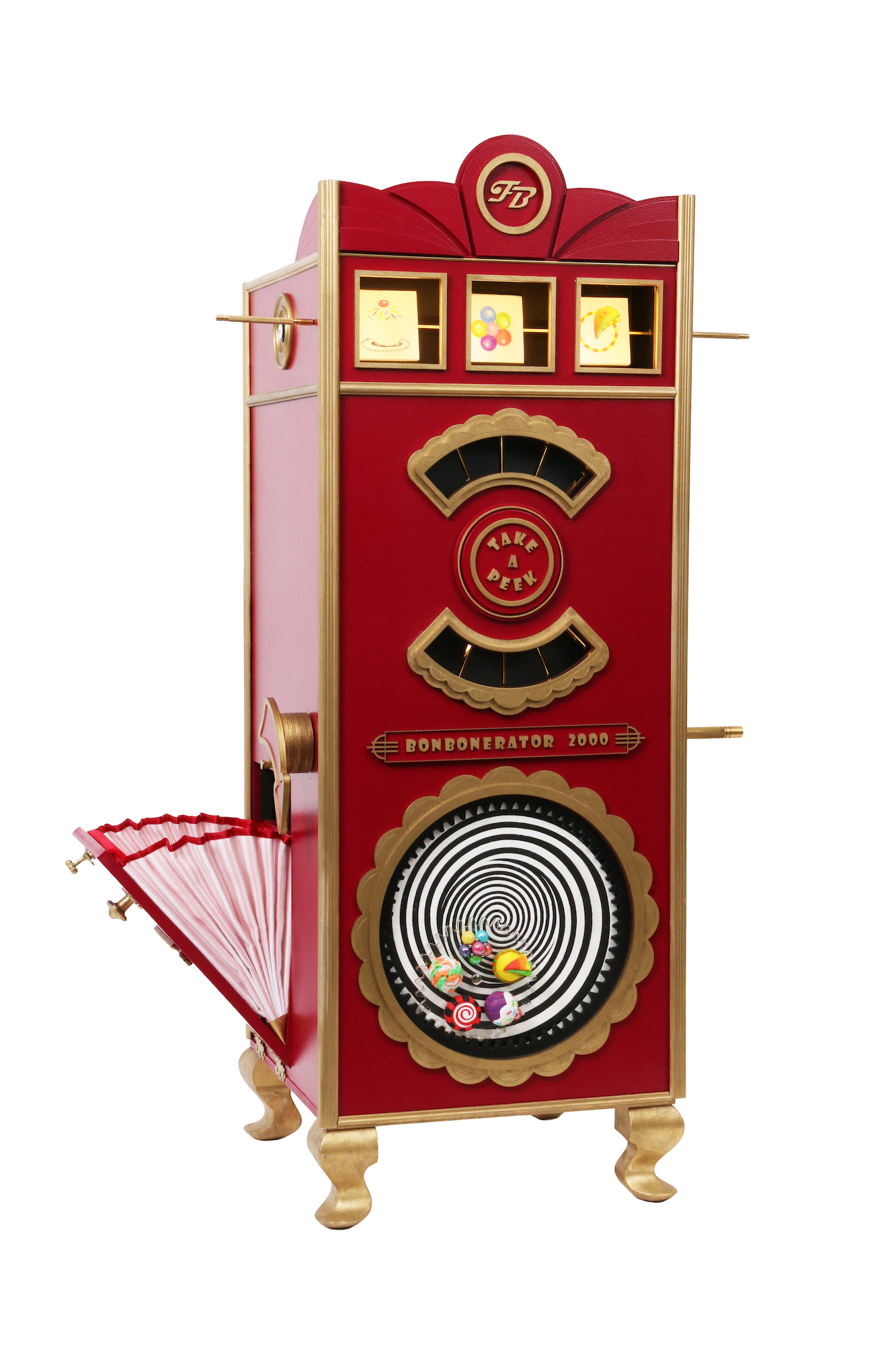 A primarily red model machine with various windows and an optical illusion-style spiral on the front, and a compartment open at the left-hand side.