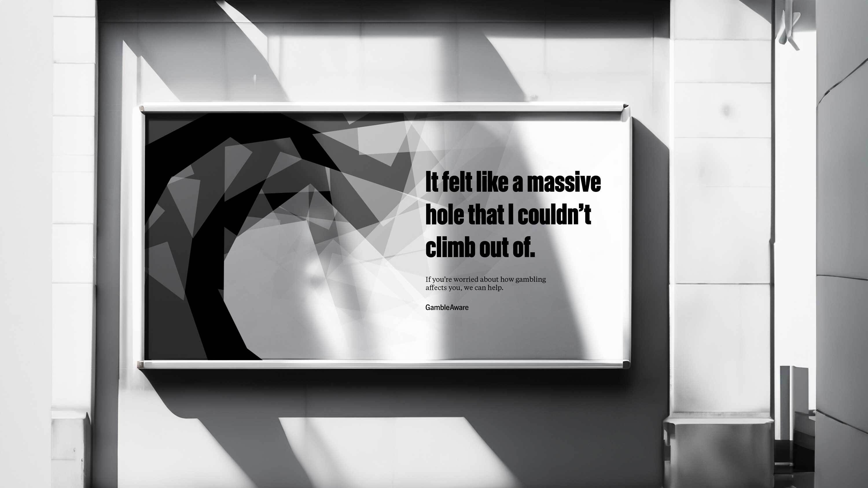 Black and white display screen in modern white corridor showing dark curved abstract shapes with text overlay.