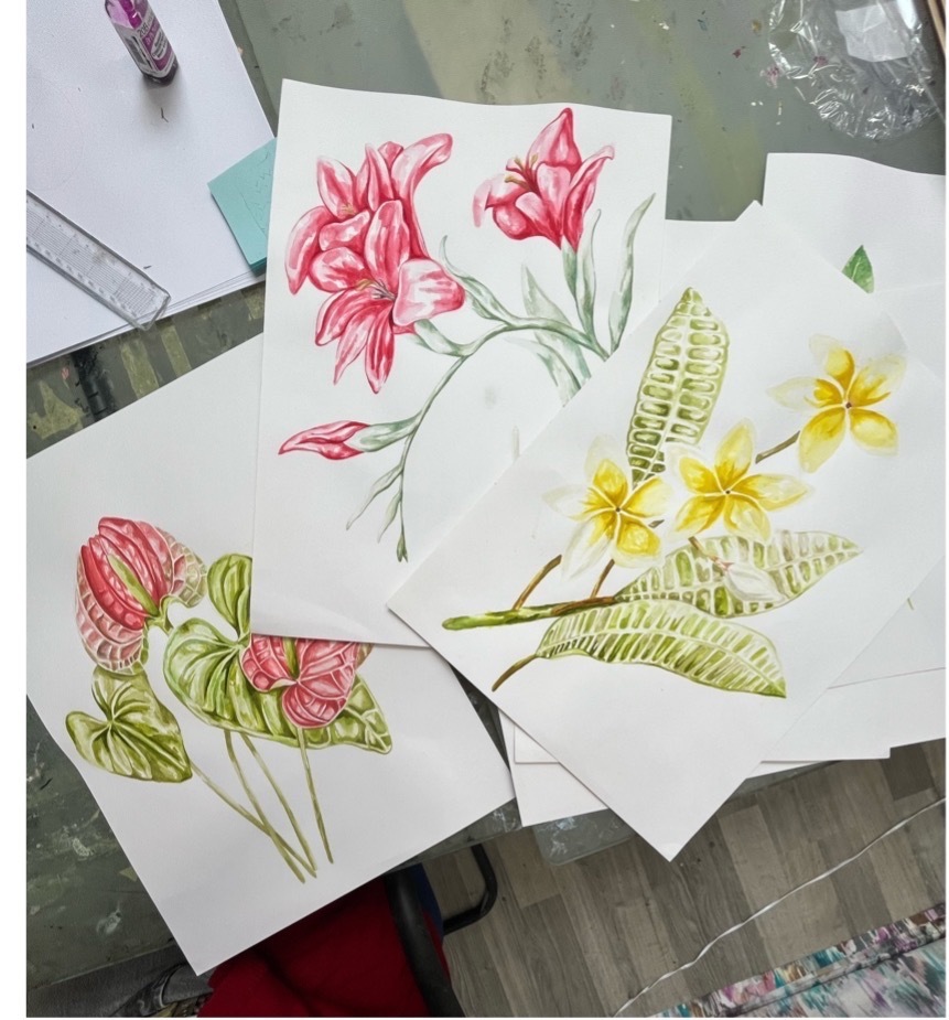 Sketches of pink and yellow flowers and leaves on paper.