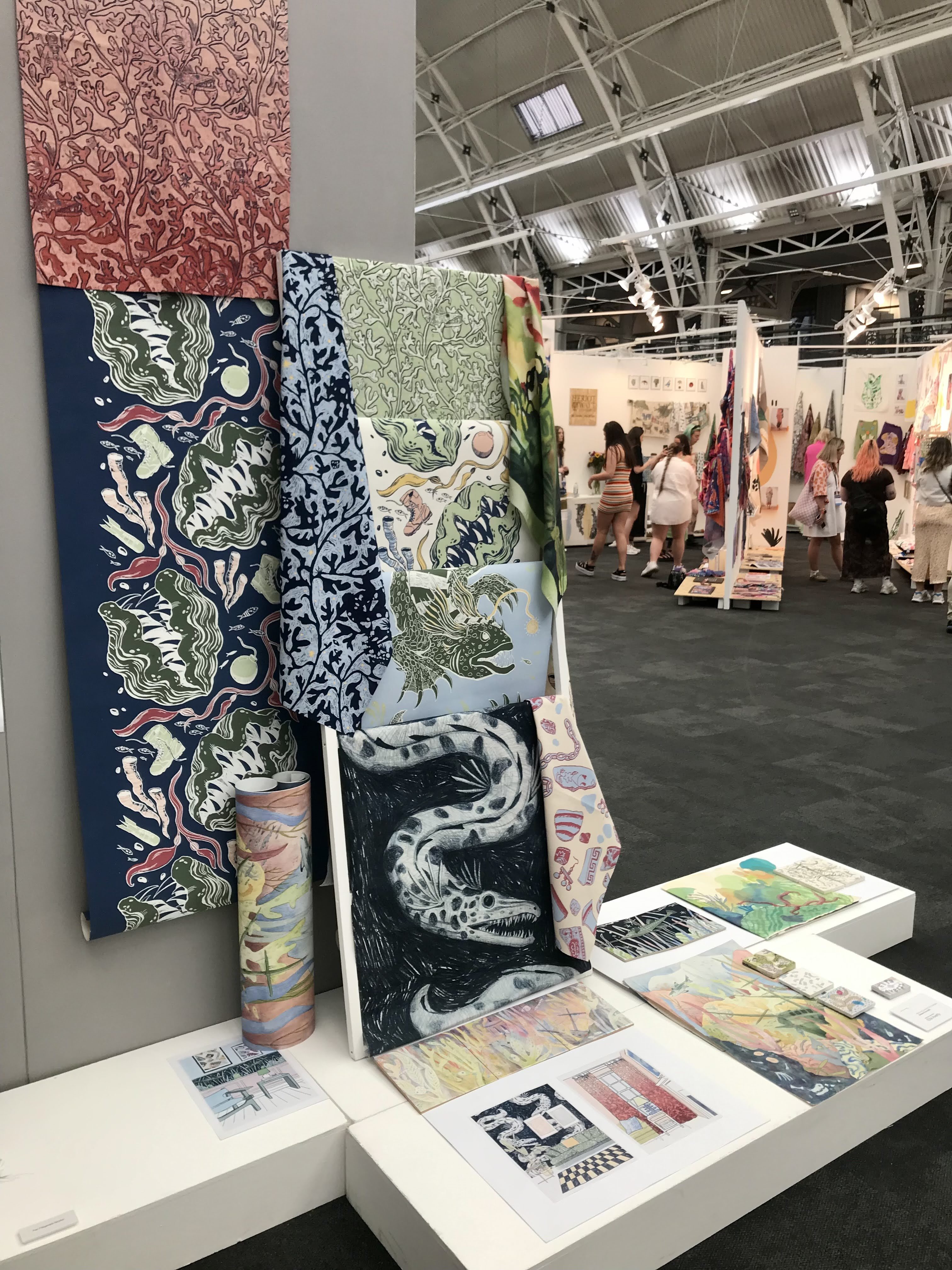 A collection of oceanic, floral and creature illustrations at an exhibition.
