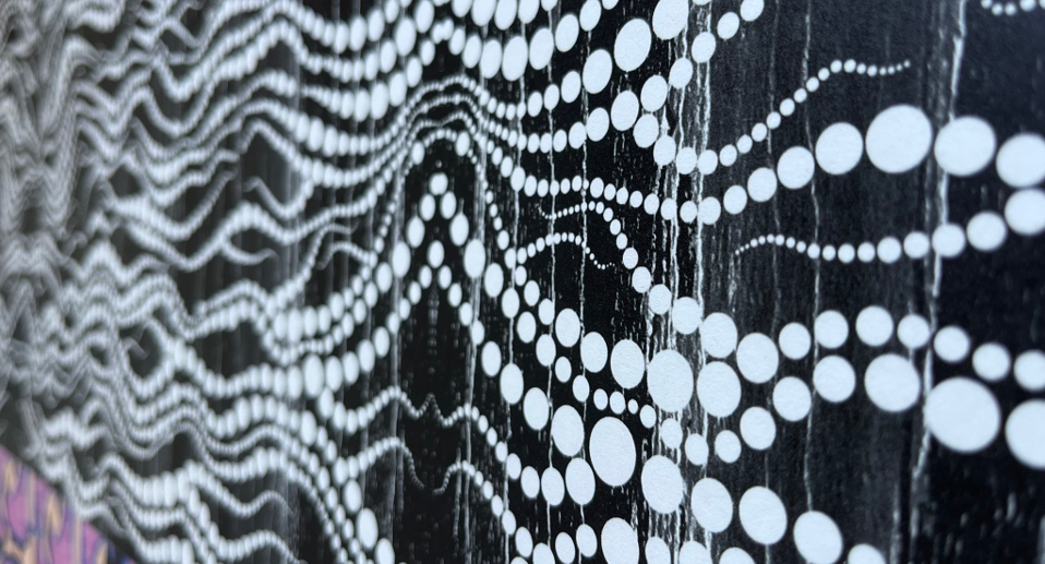 Black and white geometric patterns on fabric or wall featuring zigzag lines, circles, dots, and curved shapes in contrasting monochrome design.
