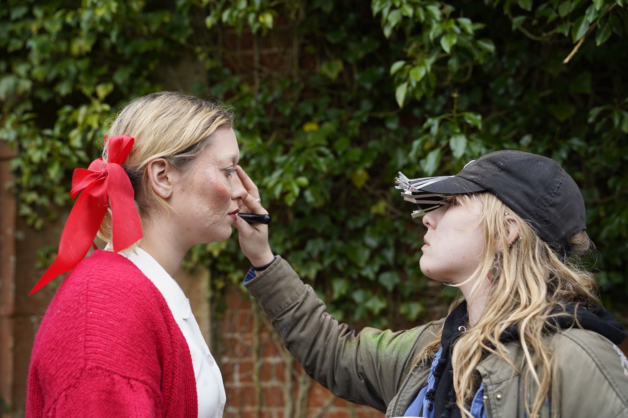 BTS shot of Four Have a Jolly Good Time, crew member adjusting make-up.