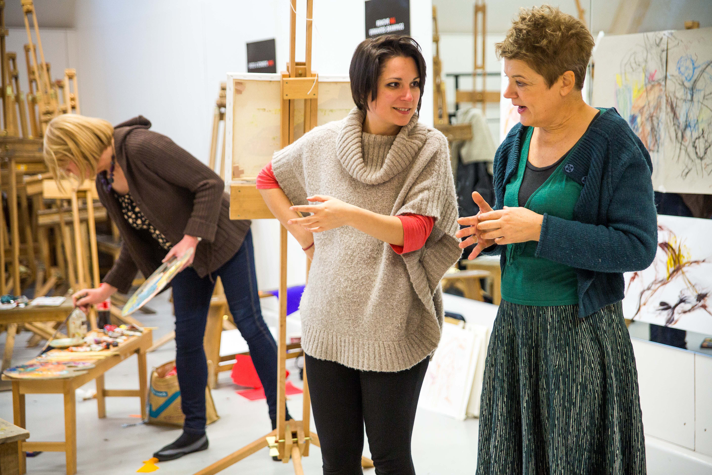 Two people discussing a painting in an art class
