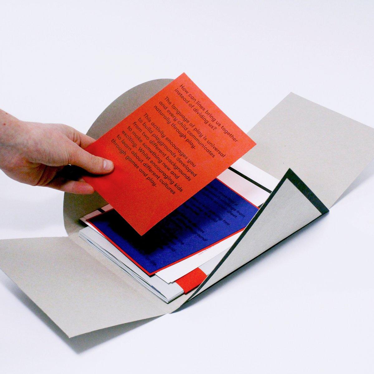 Several loose pieces of printed graphics within a folded case