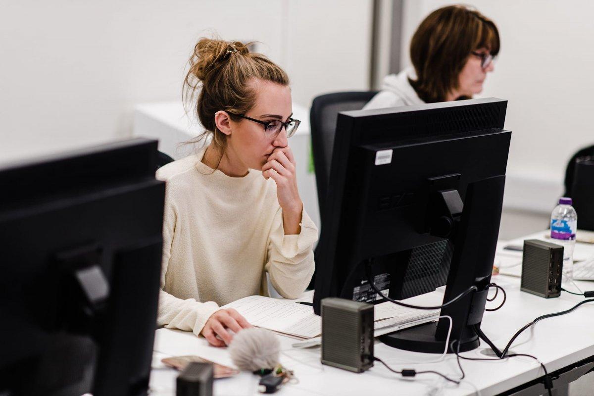 Student sat at a desk working on a computer.