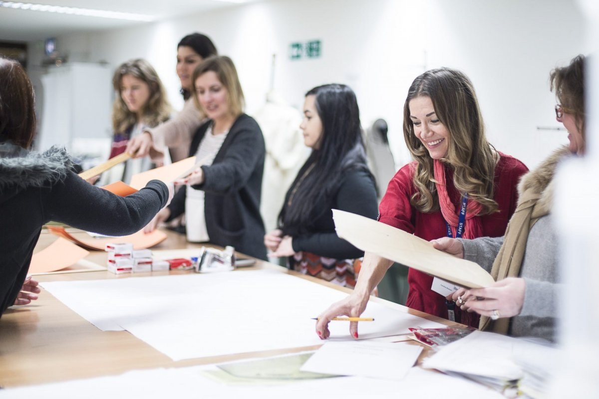 Textiles students interacting around a large table