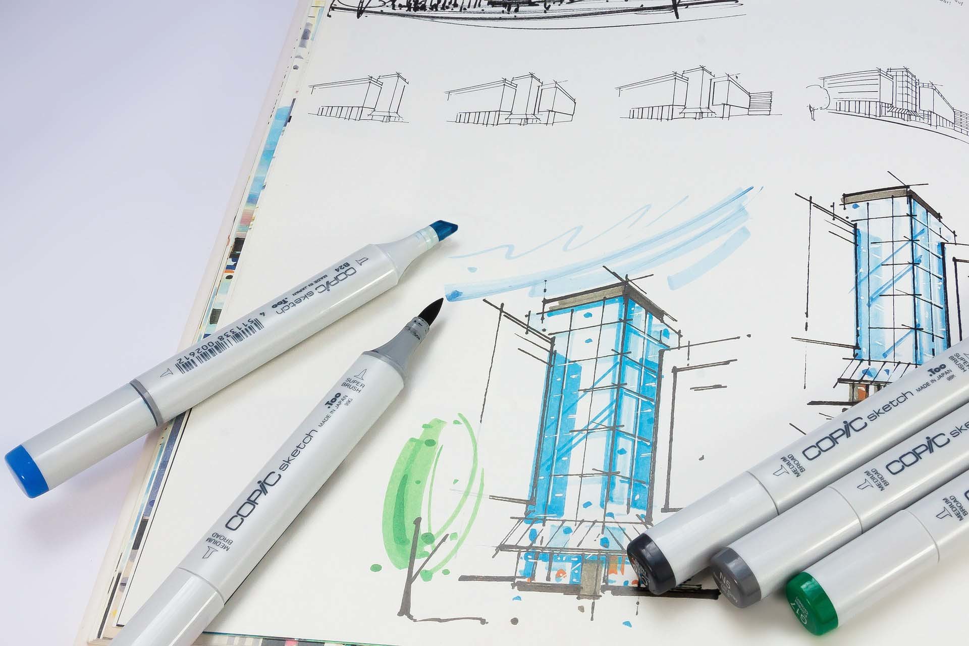 Design pens on top of a partially coloured building illustration and sketches.