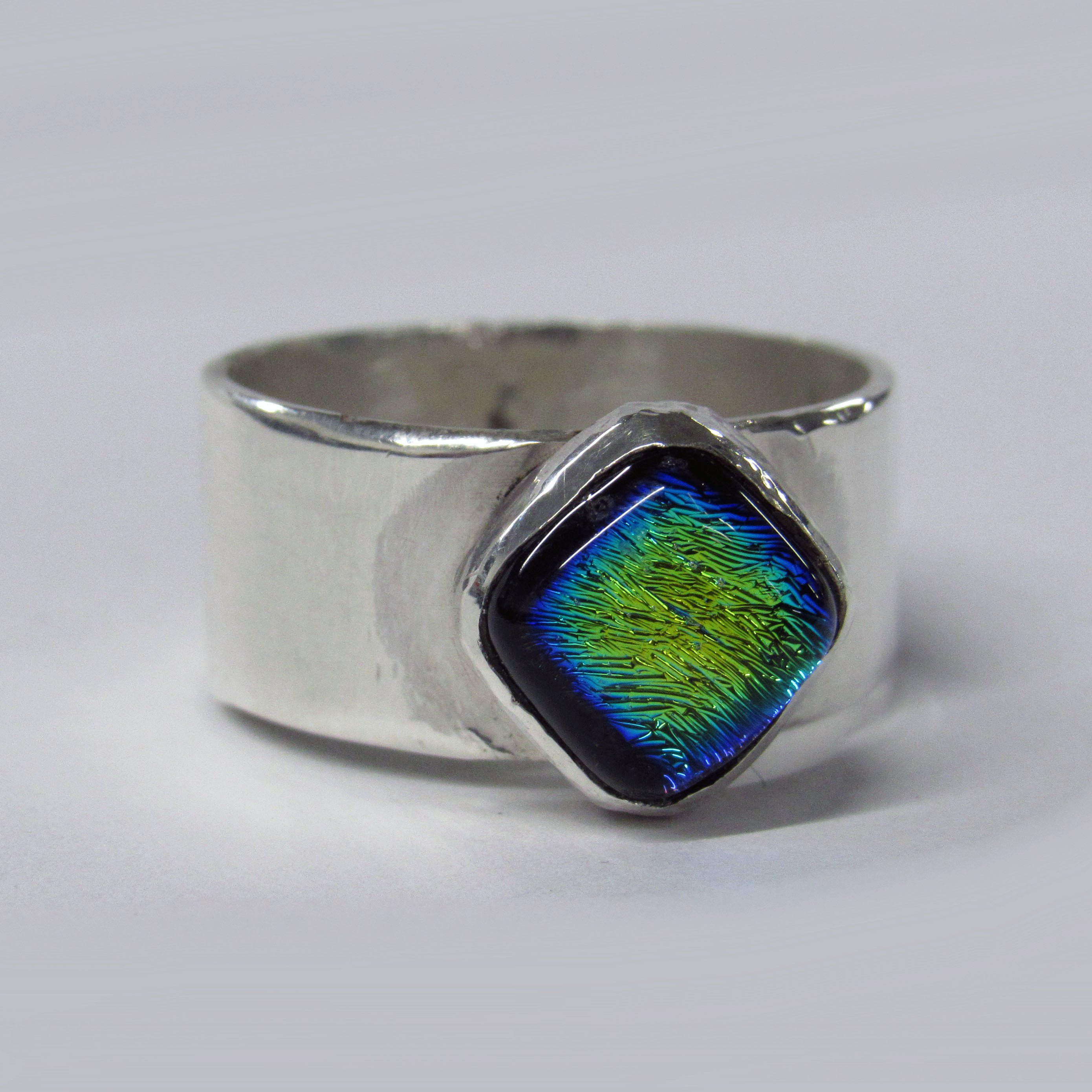 Silver ring with a blue and green gemstone in the centre.