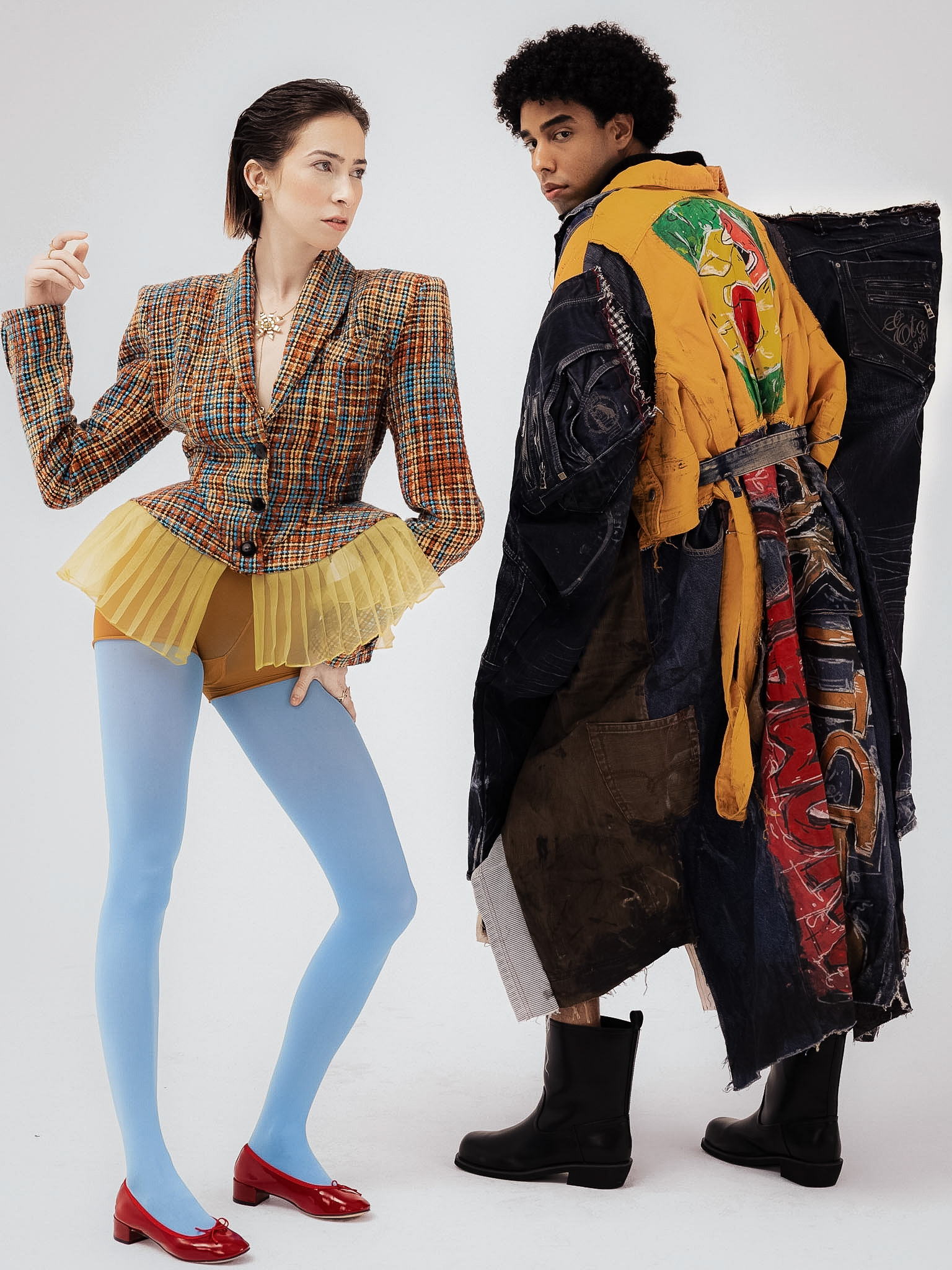 Two fashion models in diverse, colourful outfits posing for a fashion shoot.
