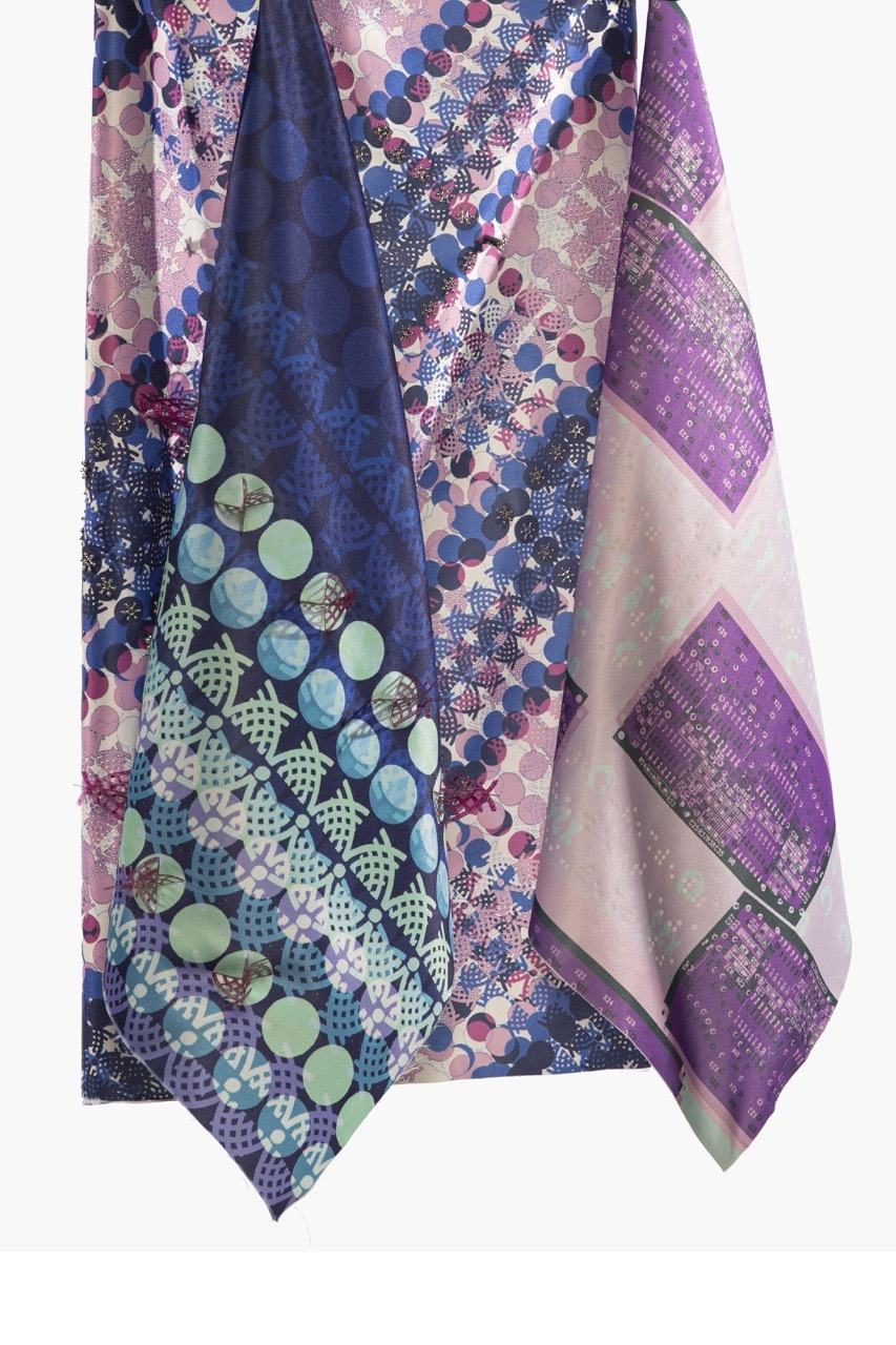 Layered fabric pieces with geometric patterns in navy, purple, pink and cream. Circular dots, hexagonal shapes, and mixed print designs.