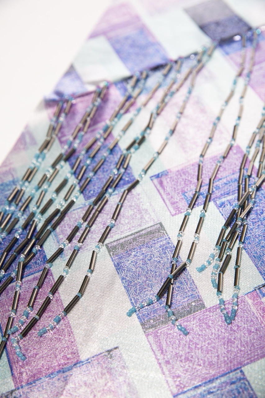 Abstract illustration with purple, blue and white geometric shapes overlaid with scattered dark linear elements across the composition.