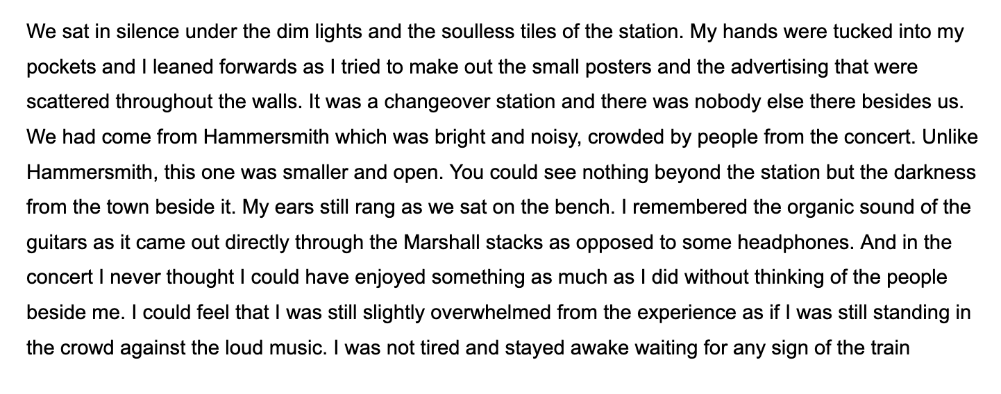 Text on a white background that reads: 'We sat in silence under the dim lights and the soulless tiles of the station. My hands were tucked into my pockets and I leaned forwards as I tried to make out the small posters and the advertising that were scattered throughout the walls. It was a changeover station and there was nobody else there besides us. We had come from Hammersmith which was bright and noisy, crowded by people from the concert. Unlike Hammersmith, this one was smaller and open. You could see nothing beyond the station but the darkness from the town beside it. My ears still rang as we sat on the bench. I remembered the organic sound of the guitars as it came out directly through the Marshall stacks as opposed to some headphones. And in the concert I never thought I could have enjoyed something as much as I did without thinking of the people beside me. I could feel that I was still slightly overwhelmed from the experience as if I was still standing in the crowd against the loud music. I was not tired and stayed awake waiting for any sign of the train'.