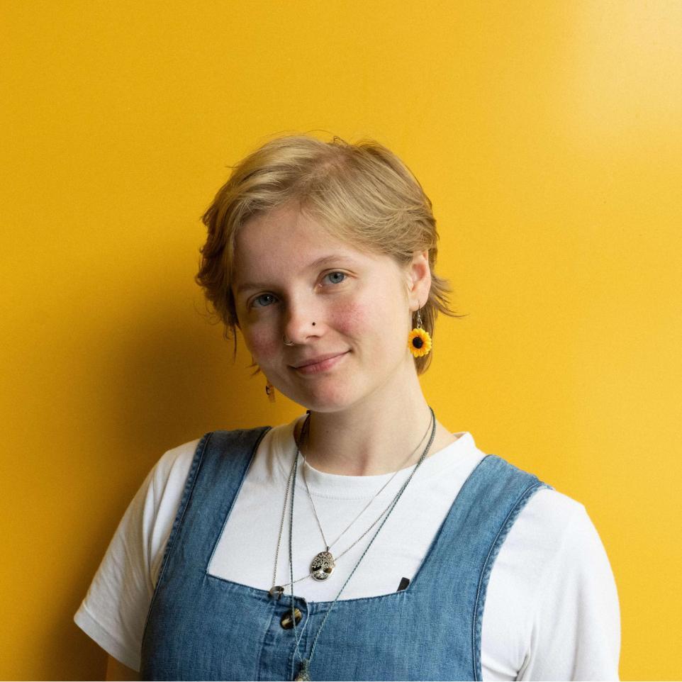 Headshot of G Parker, yellow background.