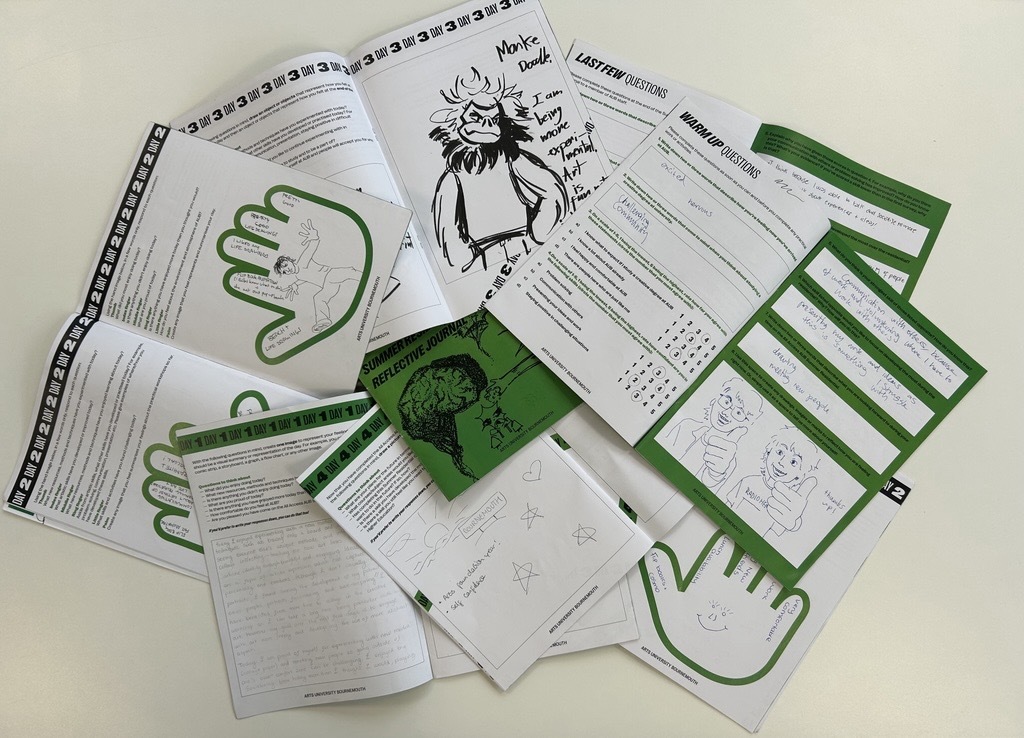 Scattered white worksheets with illustrations and text and various educational materials on beige surface.