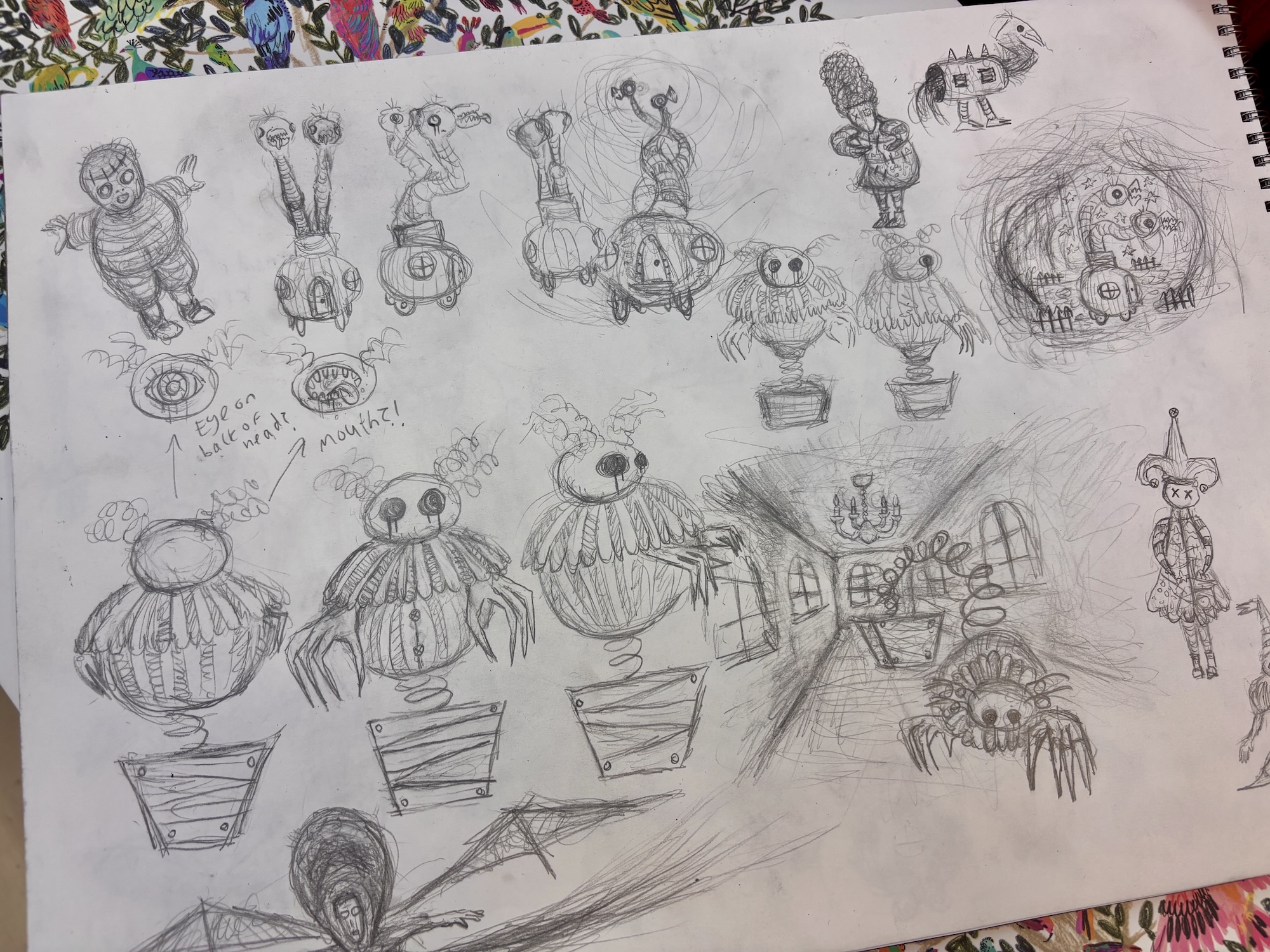 Pencil sketchbook page with multiple fantasy creature drawings, including round monster-like figures and small character studies, arranged across the sheet.