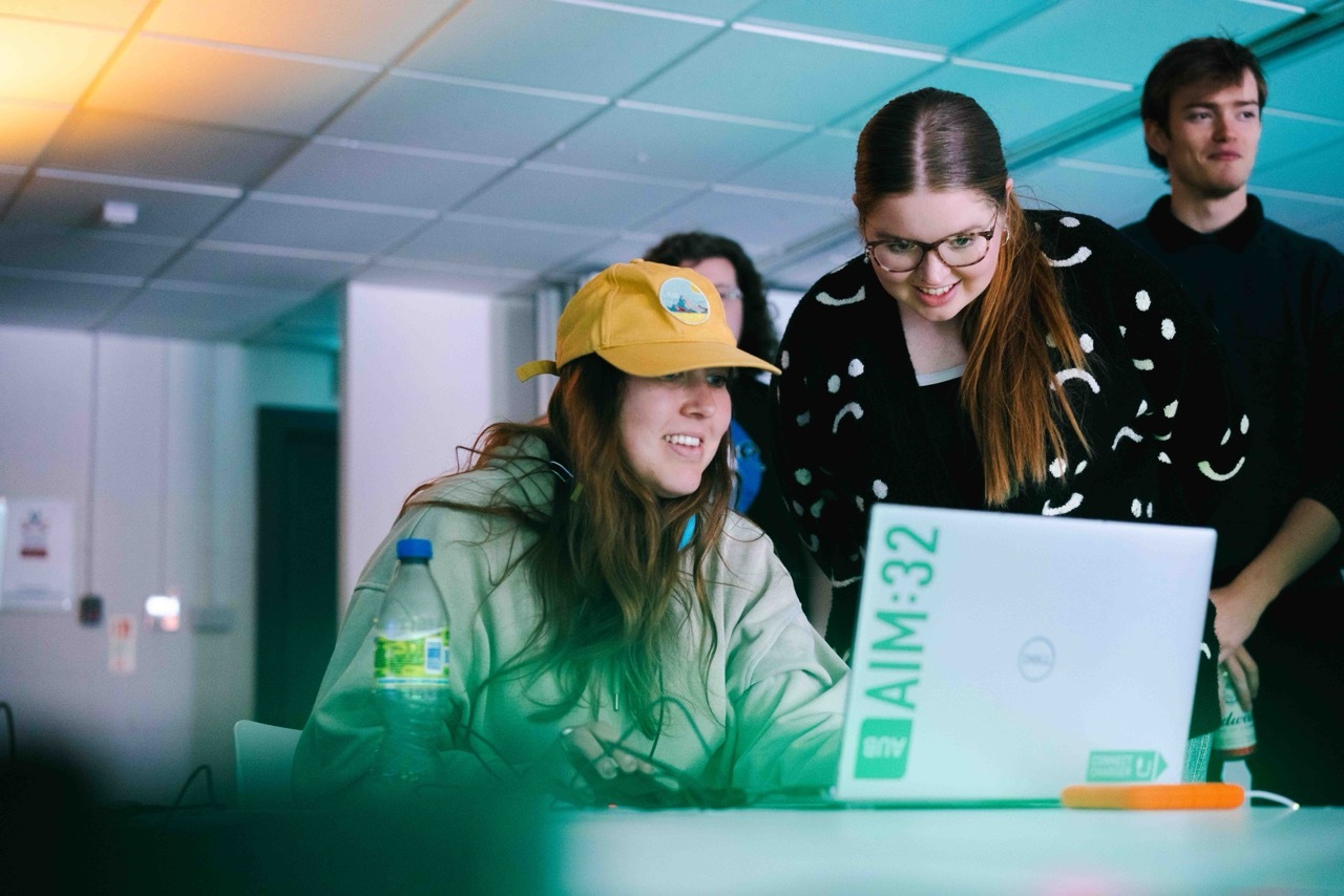 Students interacting and looking at a laptop as part of the exhibition.