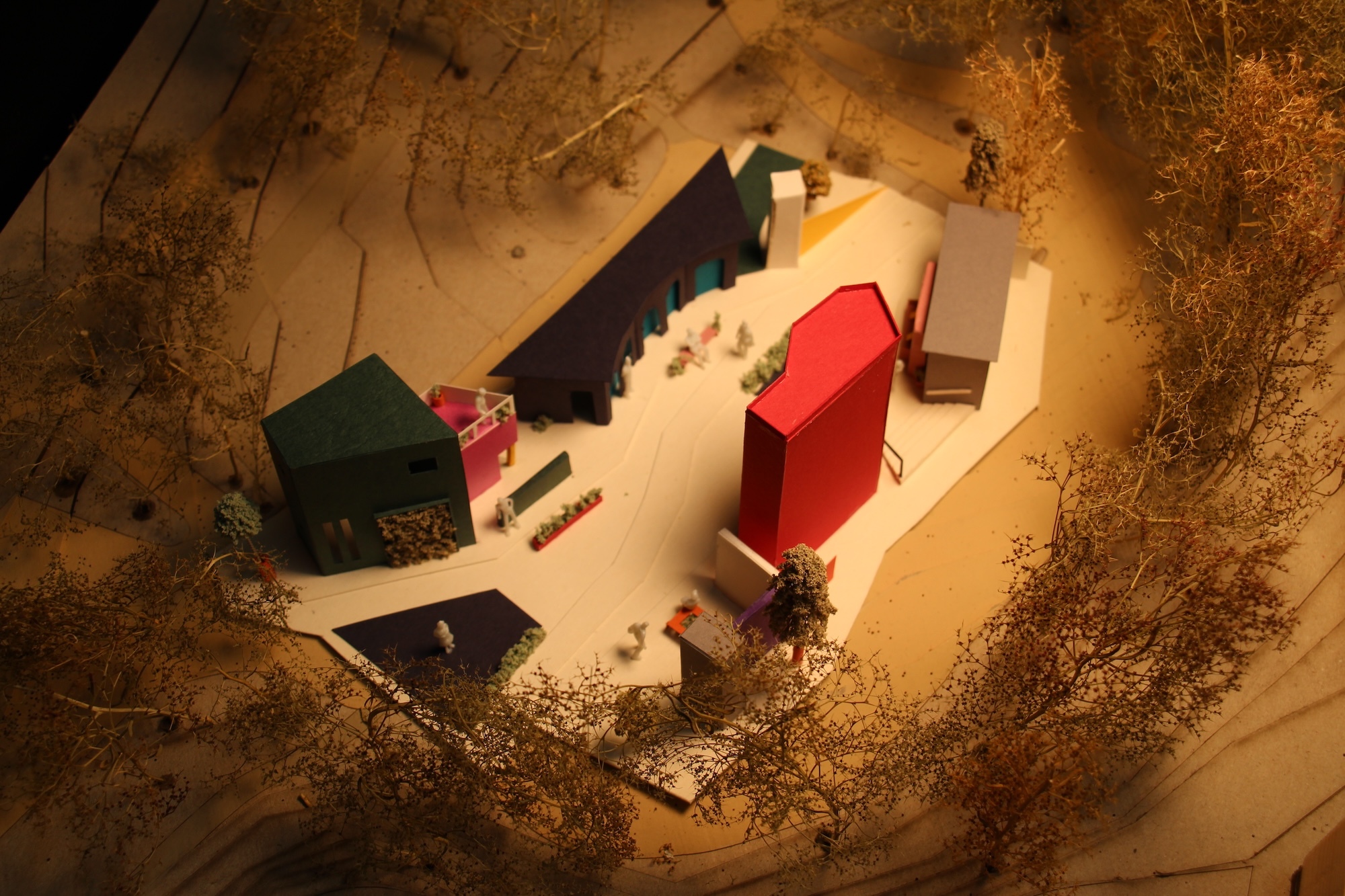 Underground stone chamber with arched ceiling containing red sofa, green furniture, and dark objects on white floor, lit from above.