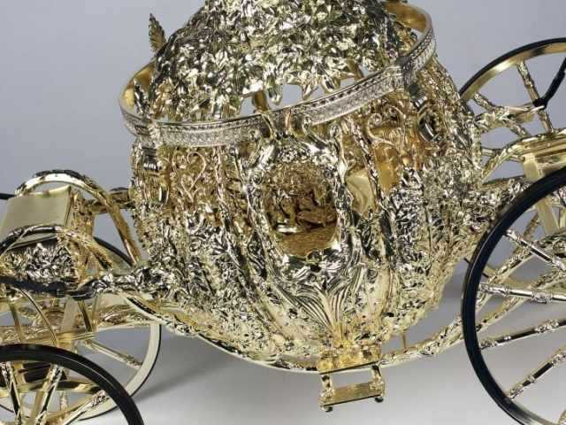 Close-up of a model of a golden Cinderella-style carriage.