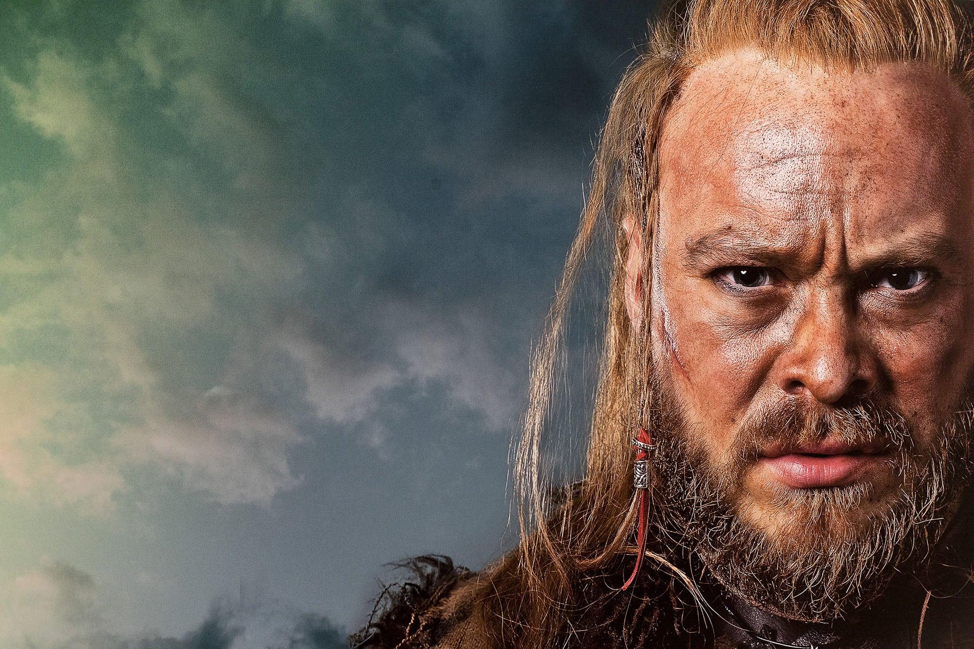 Close-up headshot of a person with Viking-style hair and make-up.