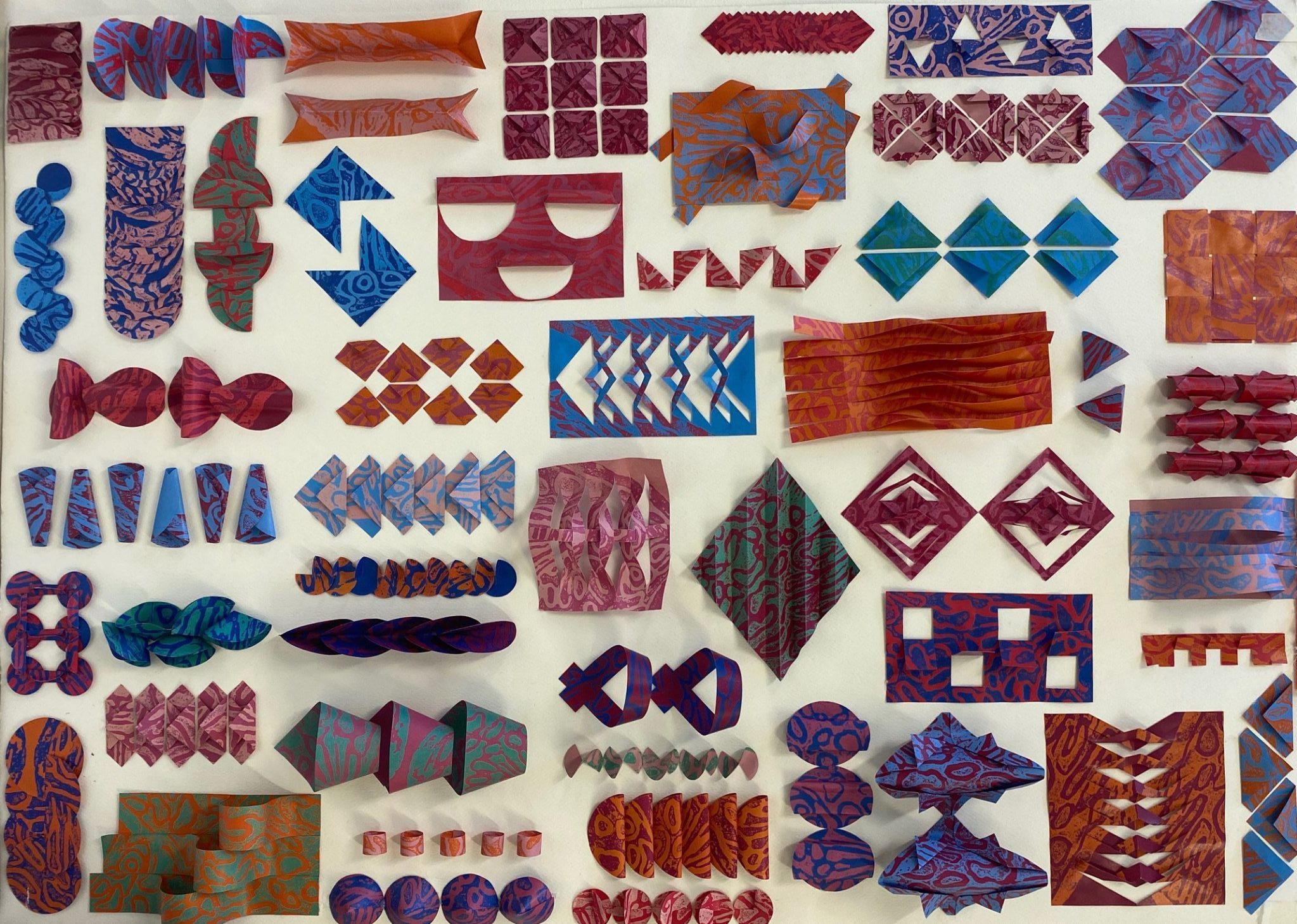An assortment of fabrics cut into different shapes and arranged on a canvas.