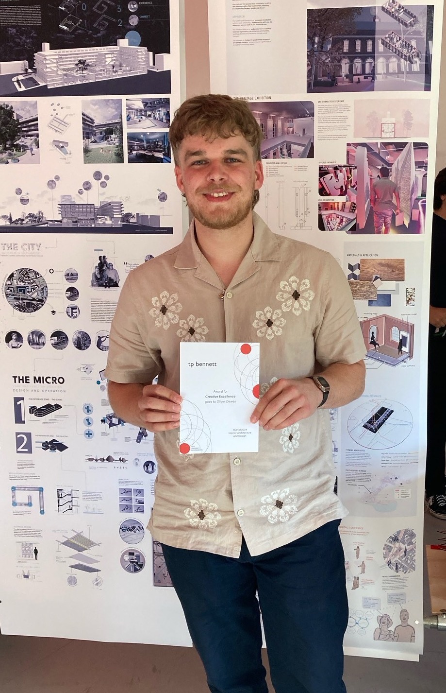 Oliver Dewes with a TP Bennett award stood in front of his work.