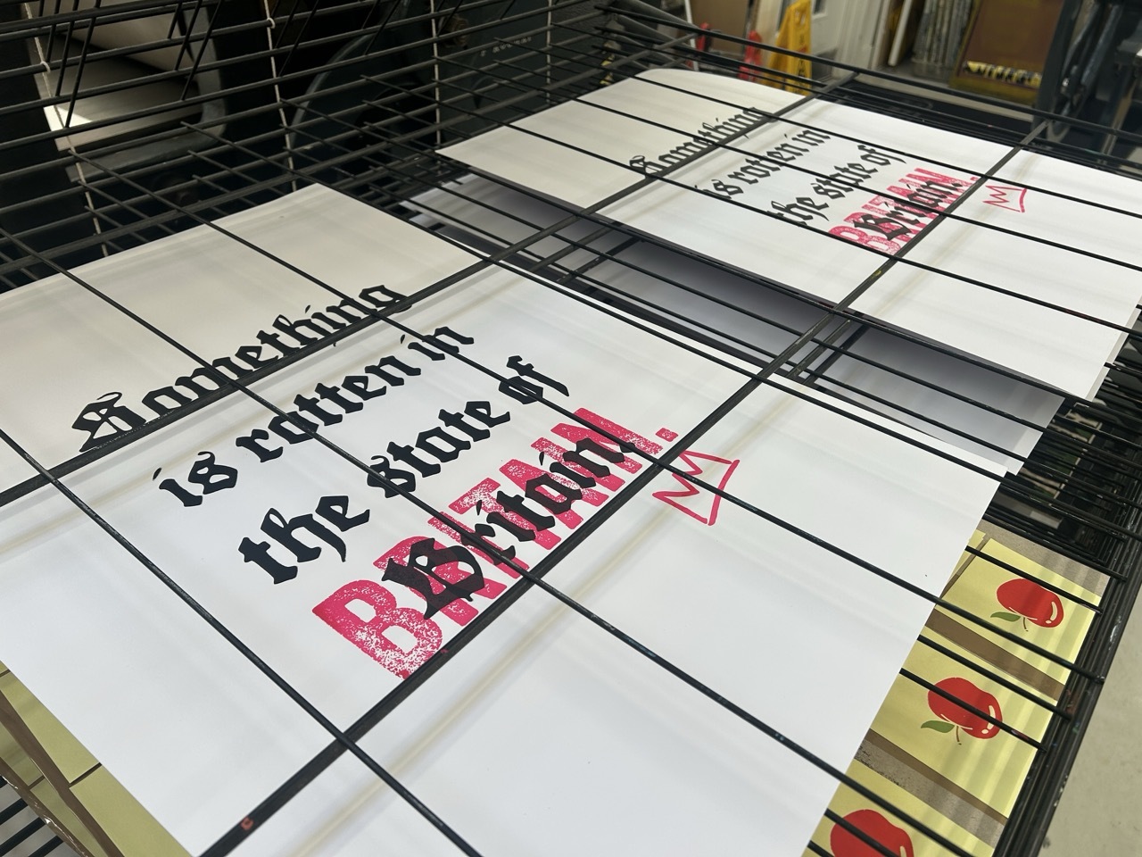 White posters with black and pink text of Shakespearian-style quotes.