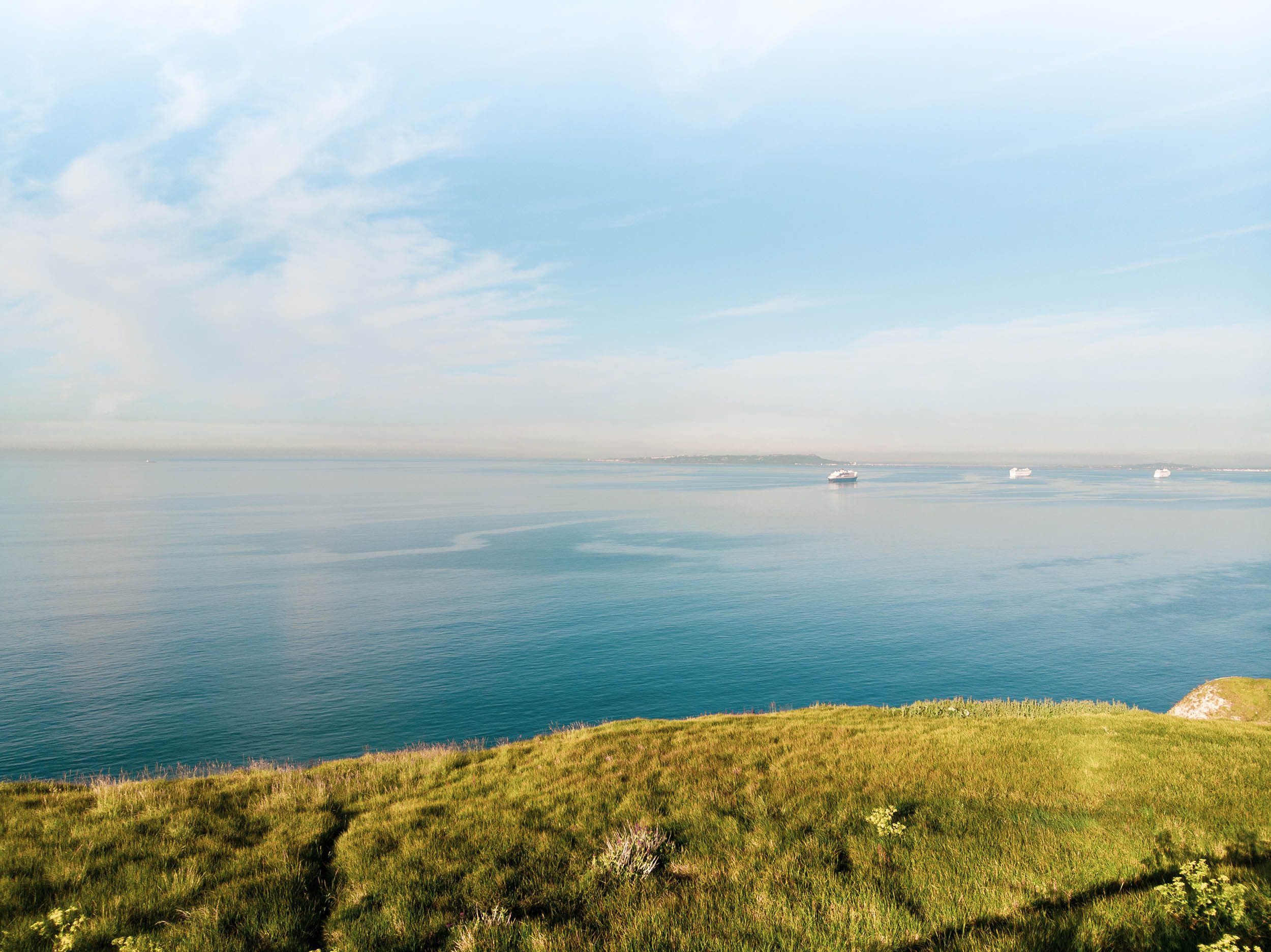 View from the shore, looking out to the sea with ferries in the background