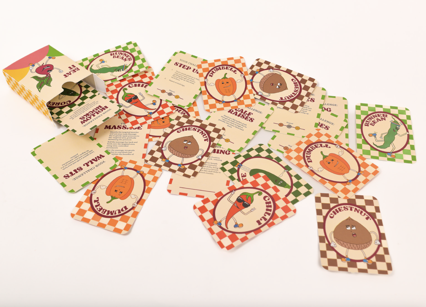 A deck of cards splayed out on a plain surface. The cards have a colourful check pattern and cartoon vegetables in the centre.