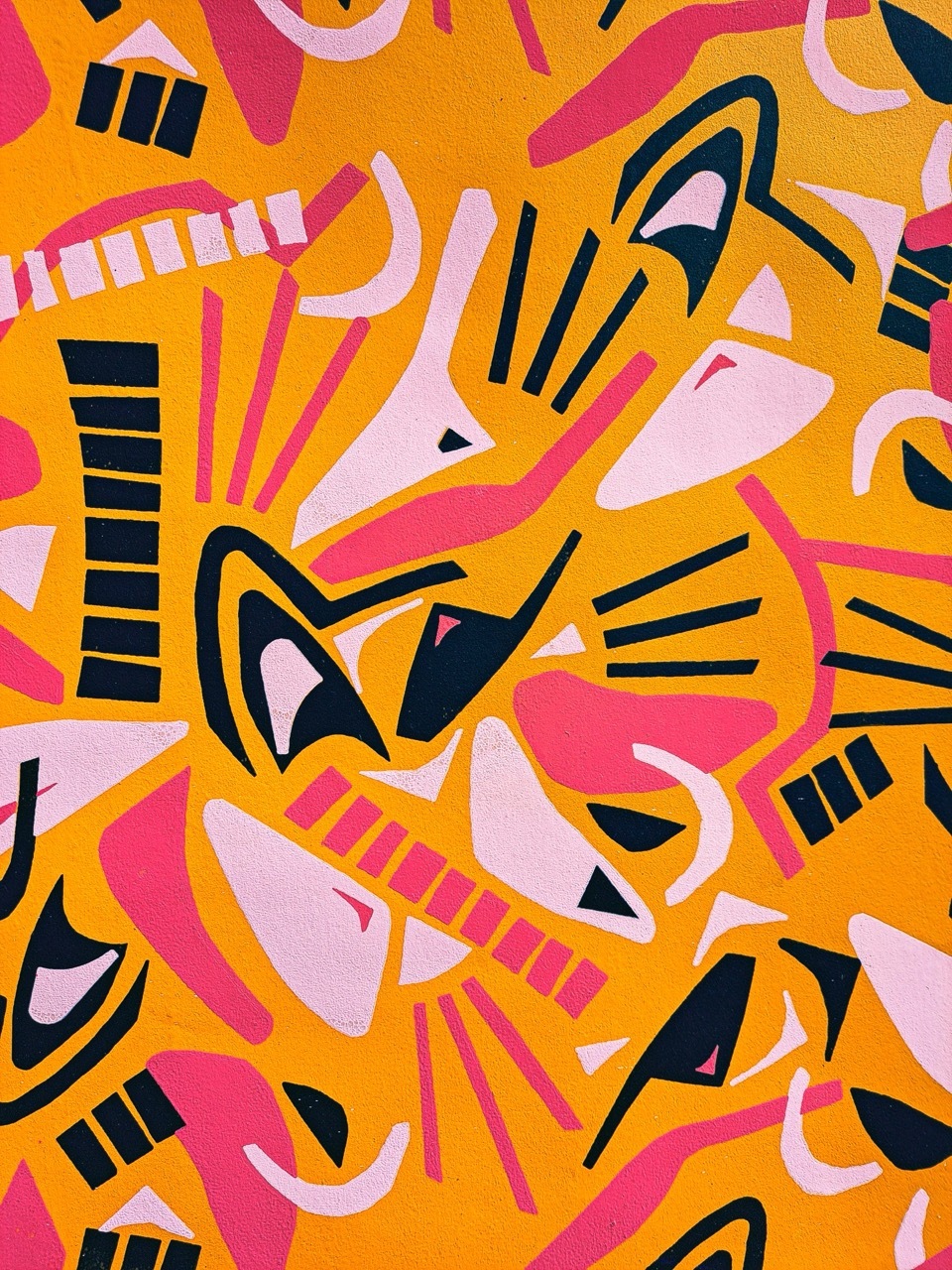 Abstract pattern with orange background featuring overlapping geometric shapes in pink, white, and black with curved lines and angular forms.