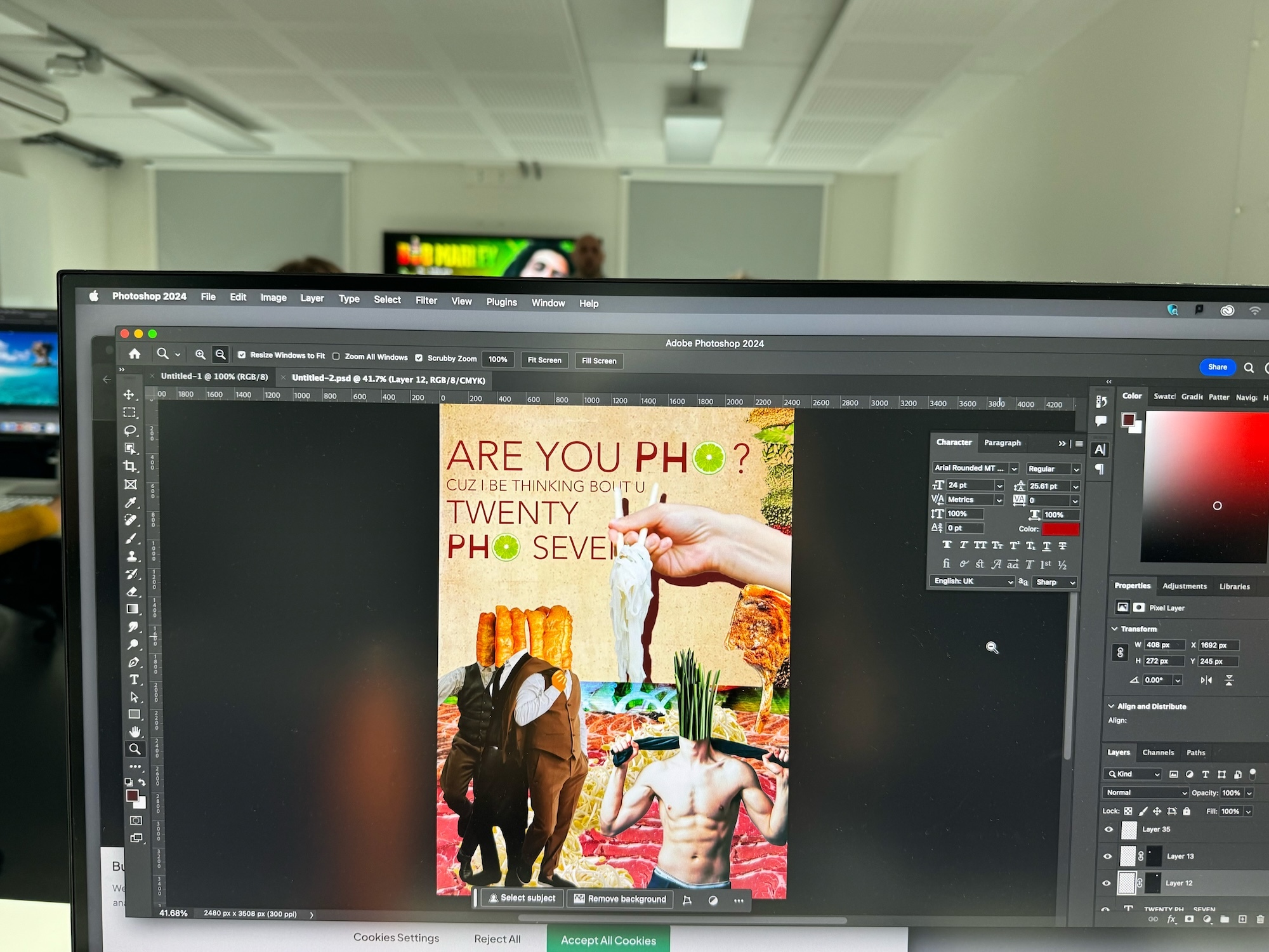 Computer monitor displaying Photoshop interface with colourful poster design featuring text "ARE YOU PH" and "TWENTY PH SEVEN" with food imagery.