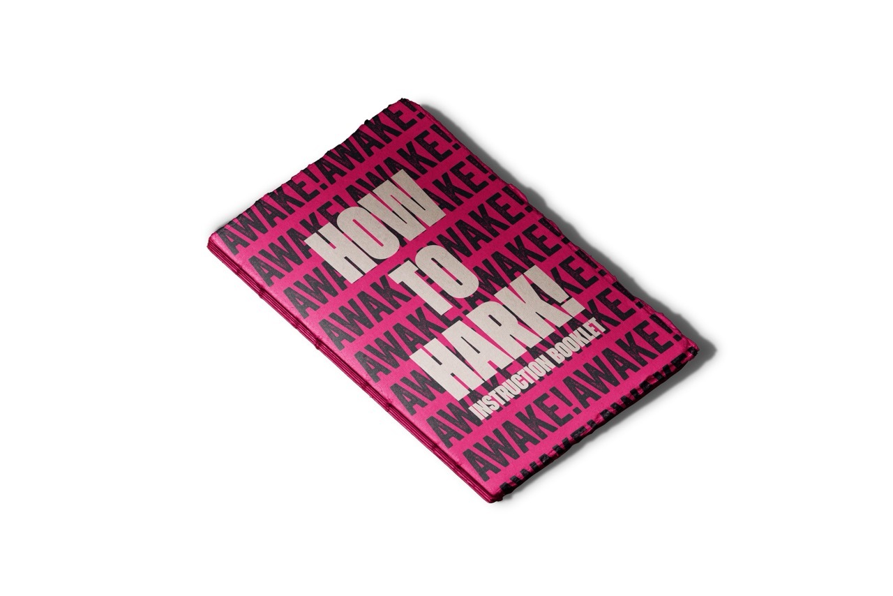 Pink booklet with white text that reads 'HOW TO HARK! INSTRUCTION BOOKLET'.