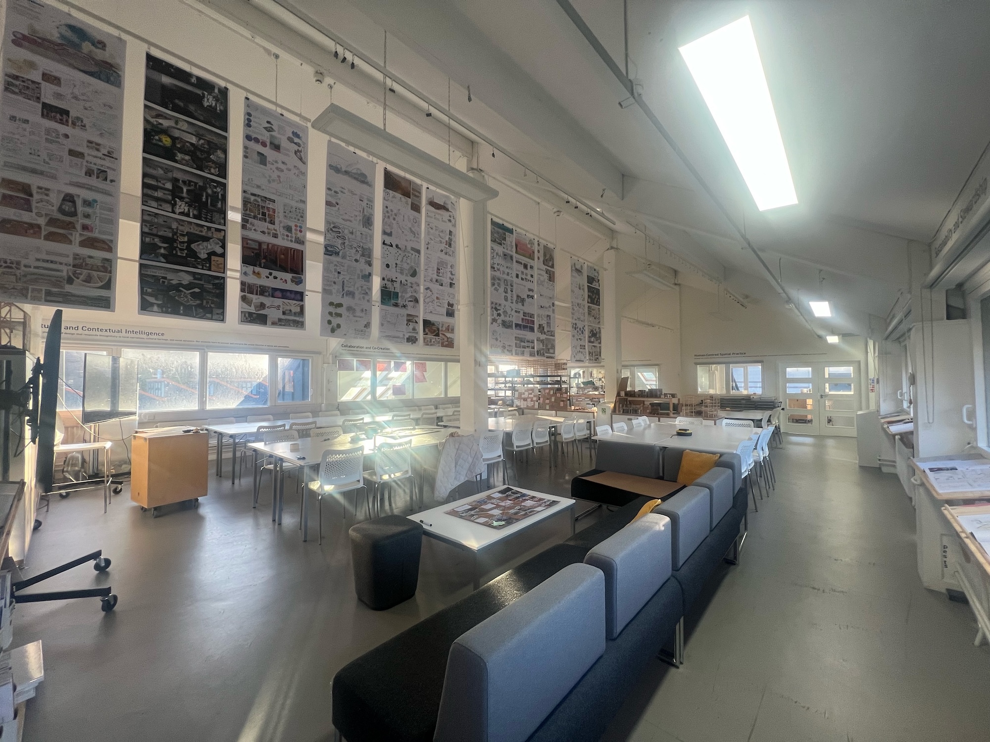 Archive room with blue storage boxes on shelves, display cases with documents, and wall-mounted informational panels under fluorescent lighting.