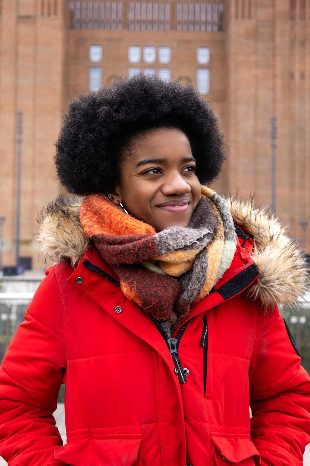 Shot of Nicole Elizabeth Phillip wearing a red coat outside.